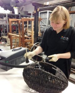 Rachael cleaning a wool basket, or mudag, in the store