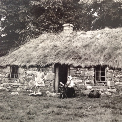 This photo is of the “Inverness-shire cottage” in the 1940s, from when the Highland Folk Museum was based in Kingussie. Mrs Grant (presumably I.F. Grant’s mother?) was spinning yarn on a wheel, a mudag to the right of her. Joan Grant was “tramping blankets”. Photo credit: Highland Folk Museum