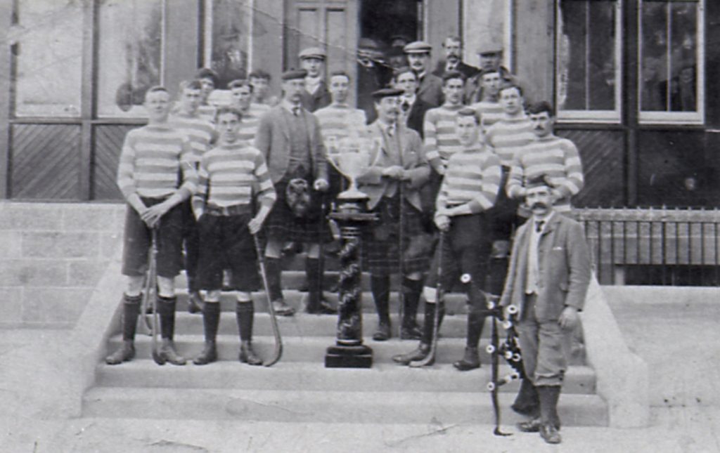 Newtonmore with their first Camanachd Cup win in 1907 on the steps of the Duke of Gordon Hotel, Kingussie. Johnnie Cattanach is second from the right on the third step back. Image credit: High Life Highland, Highland Folk Museum