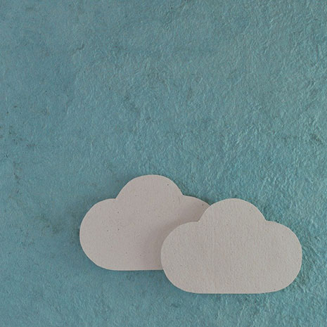 cutout paper clouds on blue card background.