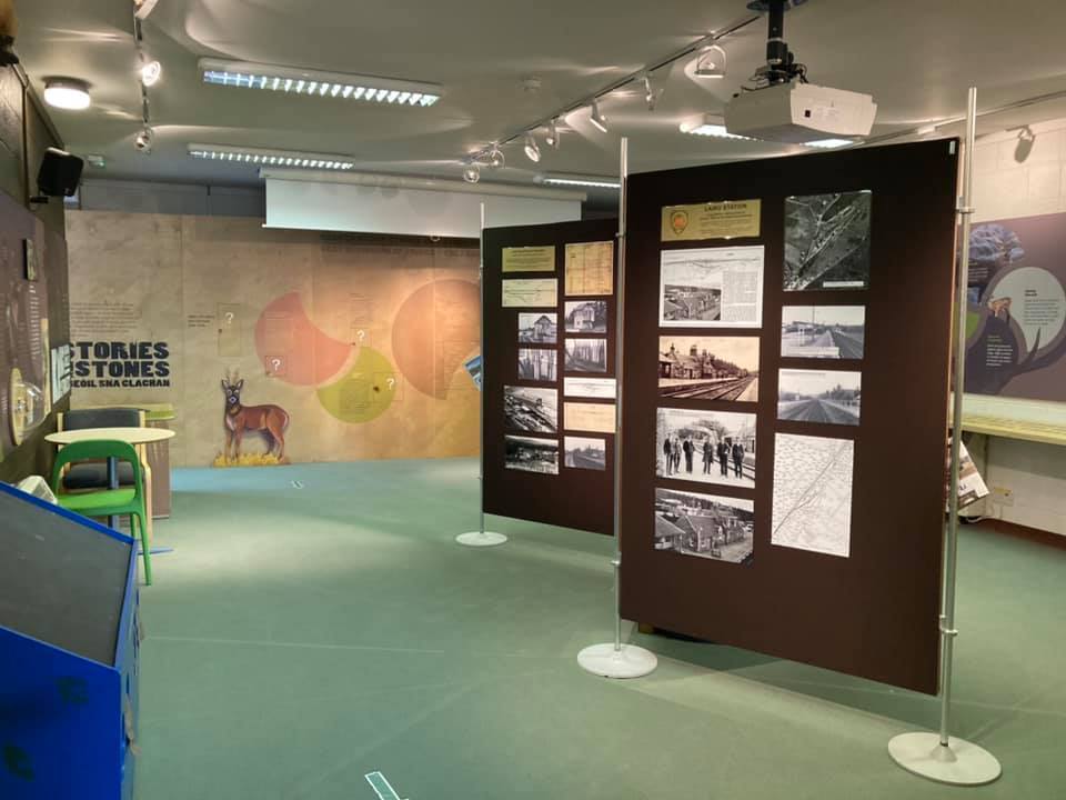 Indoor exhibition space with display boards showing historical photos and information panels