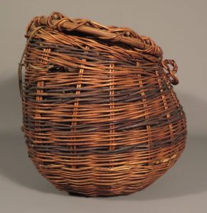 A round wicker basket with a wide opening and tightly woven sides.