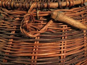 A close-up of a wicker basket showing the woven texture and a wooden toggle tied to a loop.