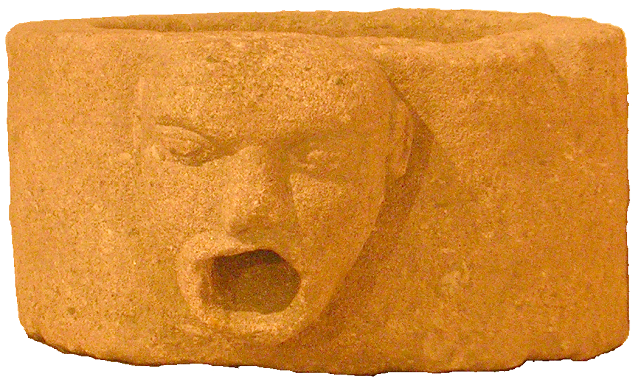 A round, rough-textured stone basin with an uneven rim and a small protrusion on one side, shaped like a face.