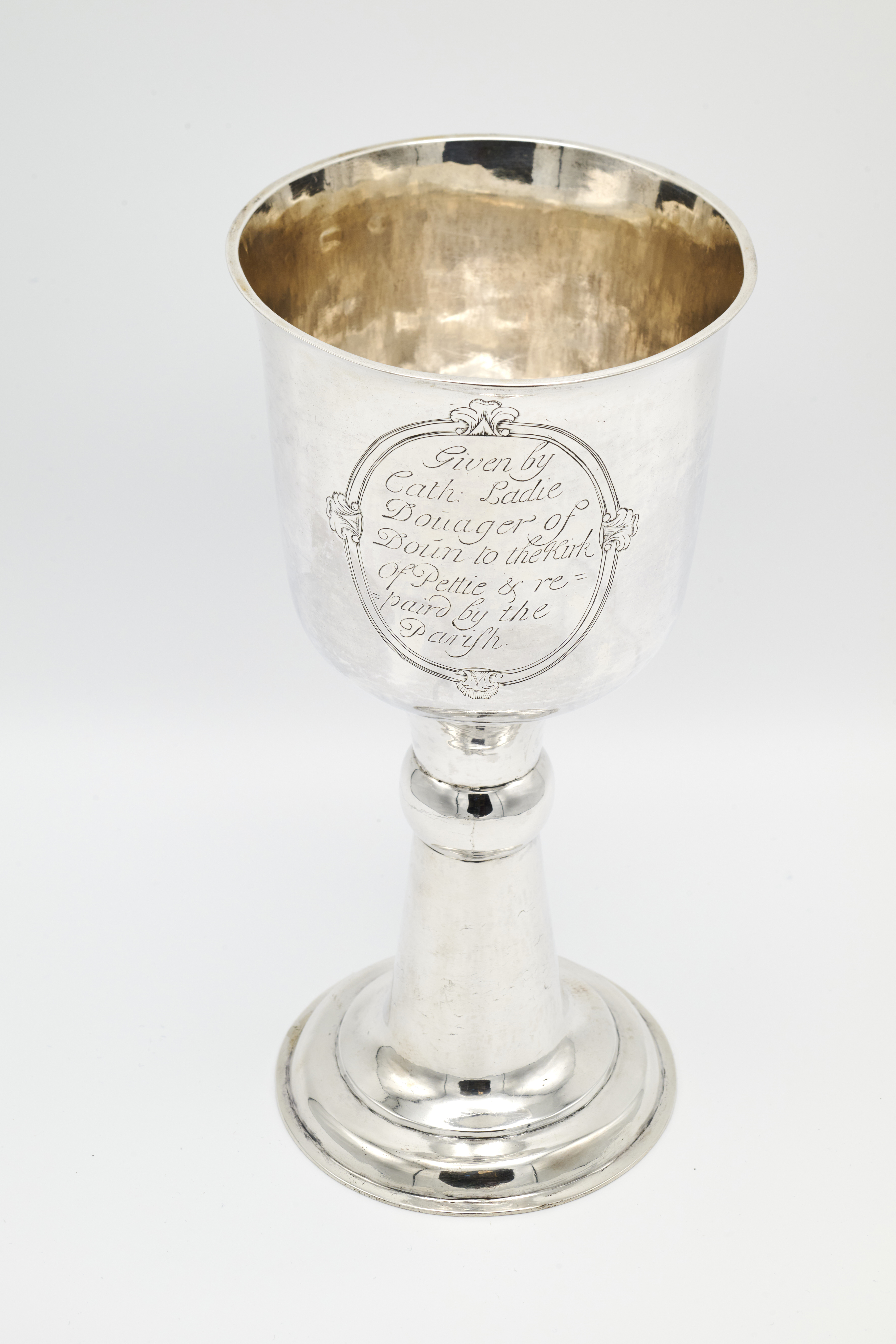 A silver chalice, with a deep cup and trumpet-shaped stem and foot.  On the front an oval panel with engraved inscription.