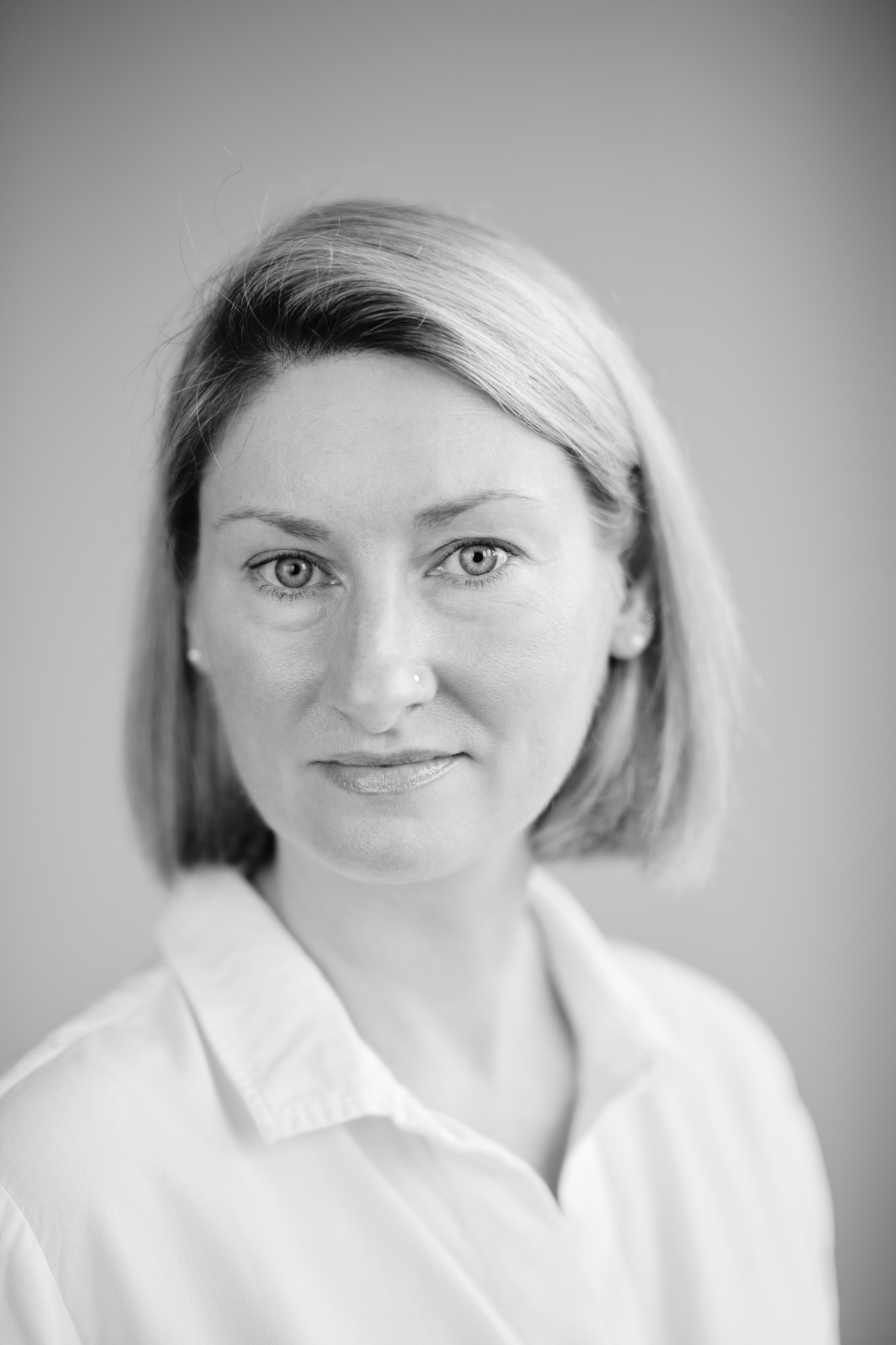 Black and white portrait photograph of silver specialist, Lyndsay McGill, shown against a plain background.  Image courtesy of Lyndsay McGill, RL Christie Works of Art.
