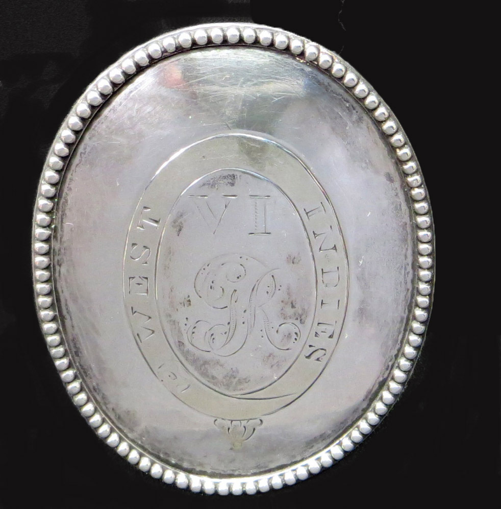 An oval metal badge, worn by a soldier, with a decorated rim and engraving in the middle.  The metal is a shiny silver colour.  Shown after conservation cleaning.