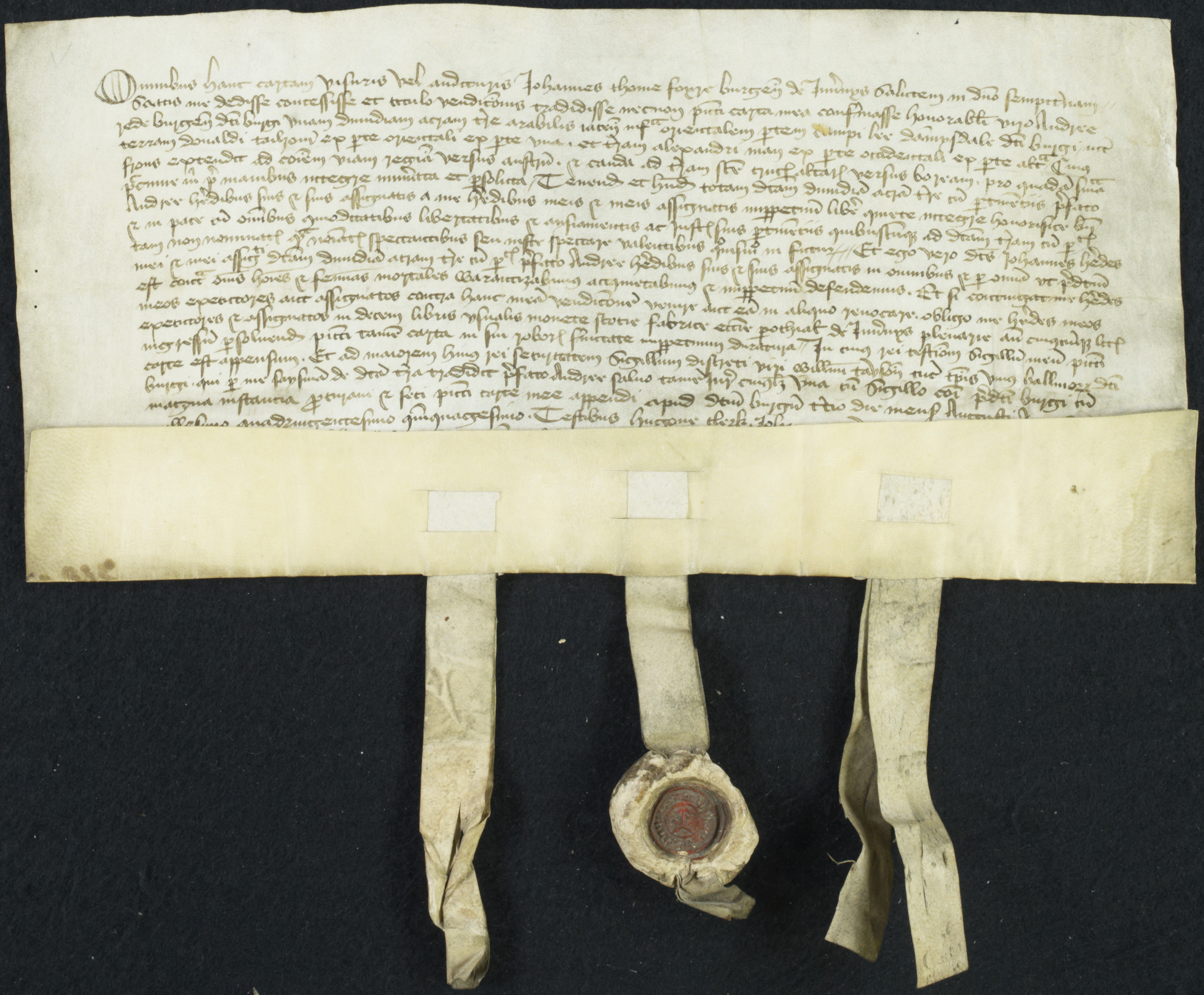 A rectangular document laid flat except for the bottom edge which folds upwards and has three tags for wax seals hanging from it.  Two of the seals are missing but the centre seal is a round blob of deep red wax.  The document is covered in narrow rows of handwriting.