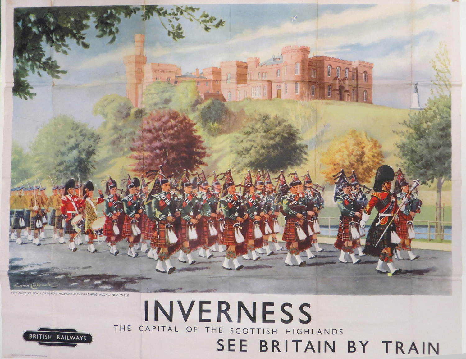 Colour poster showing a pipe band marching along the road with Inverness Castle on the hill behind, with slogan 'See Britain by Train'.