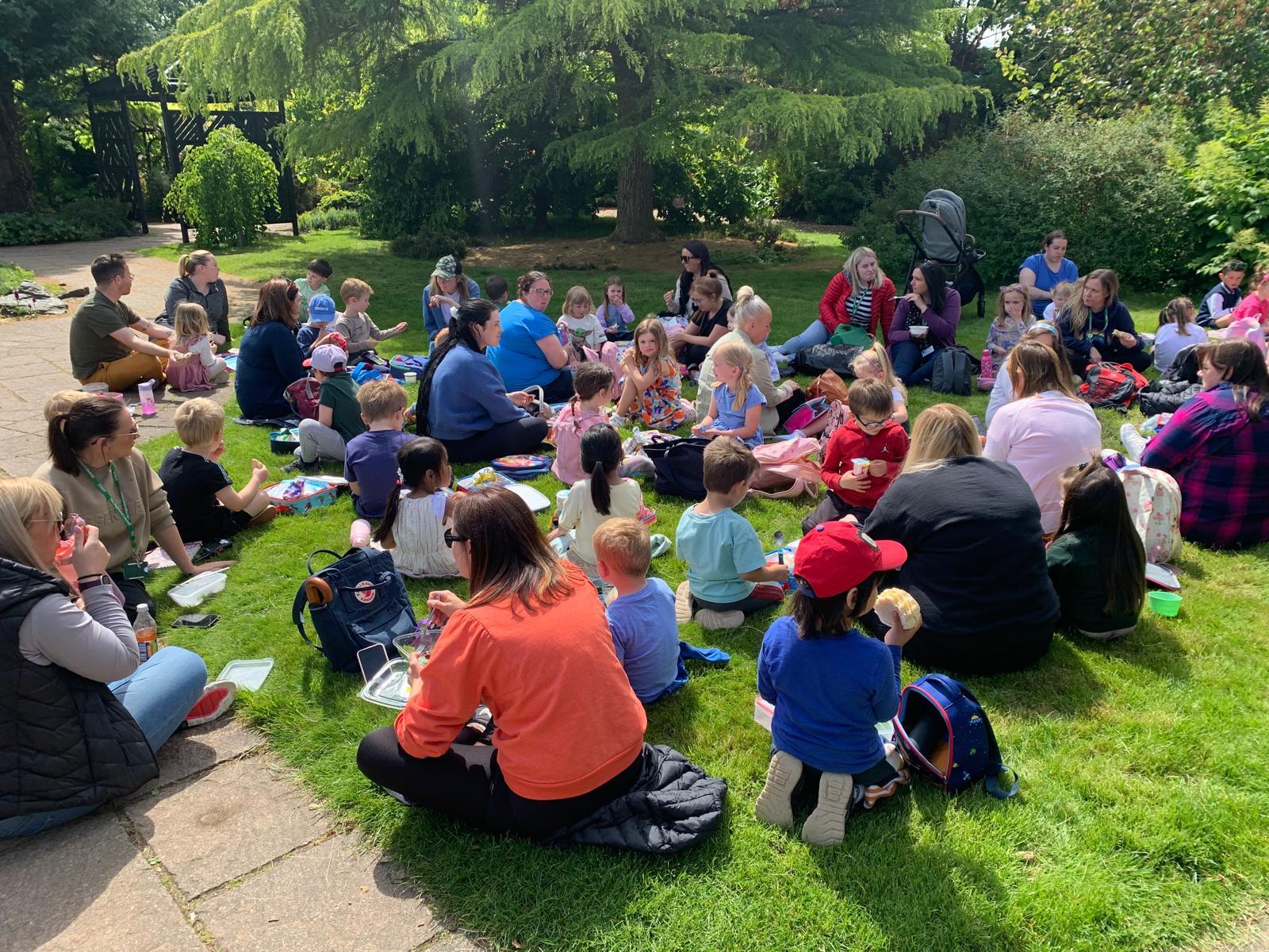 A groups of young children and their parents/ guardians intrigued by the outdoors.