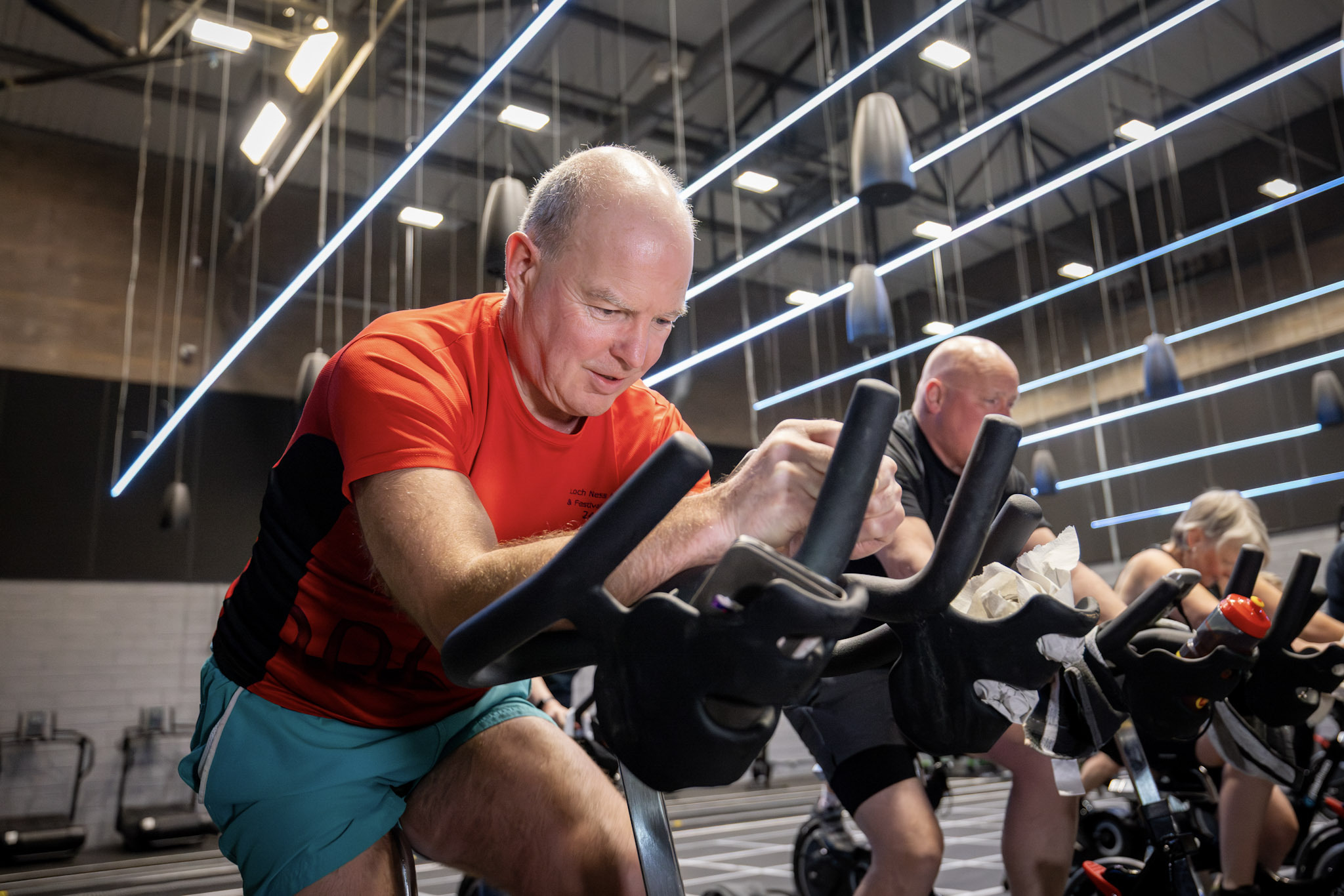 Man cycling on a spin bike during an indoor cycling class