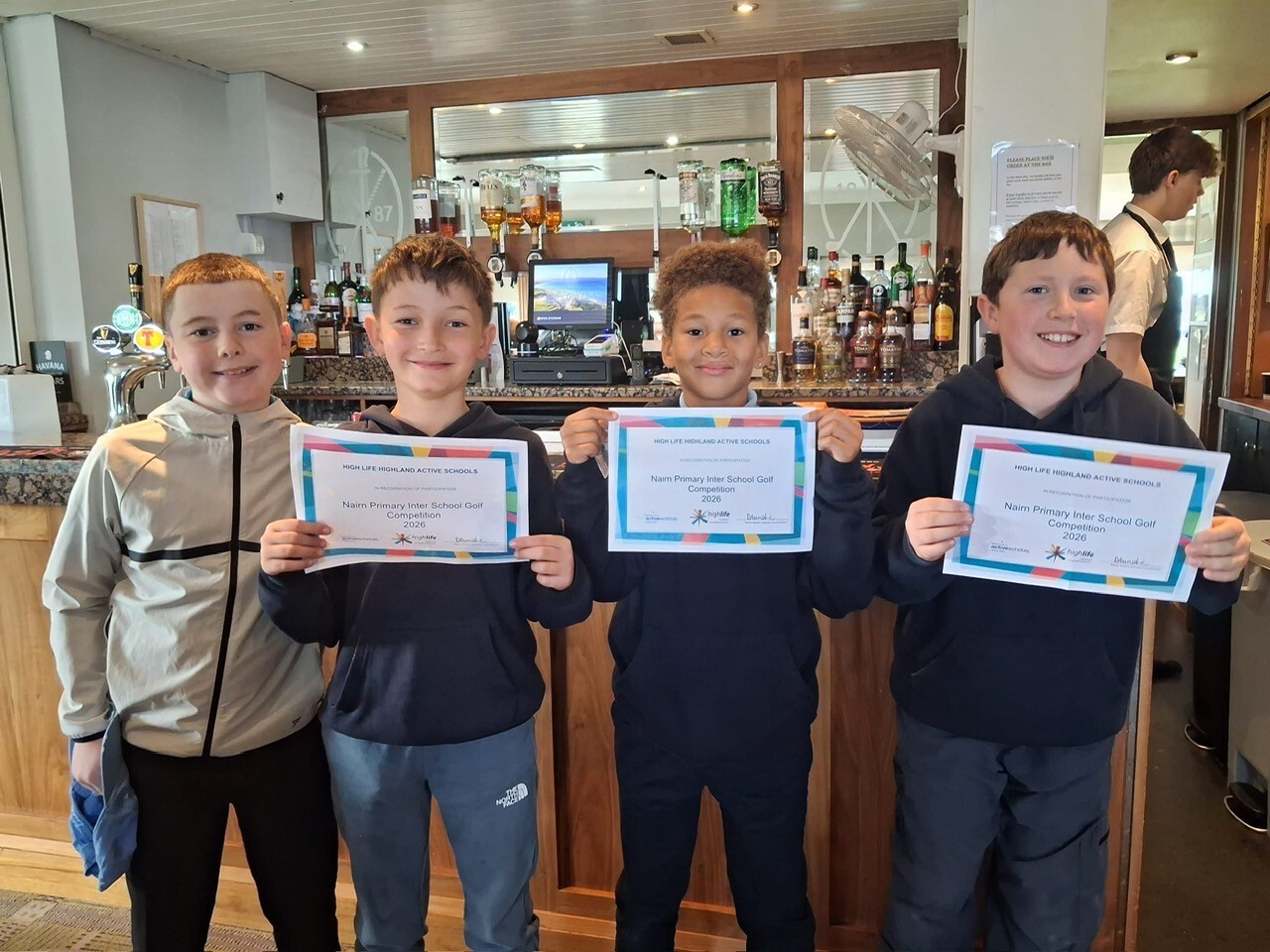 Four pupils holding participation certificates.