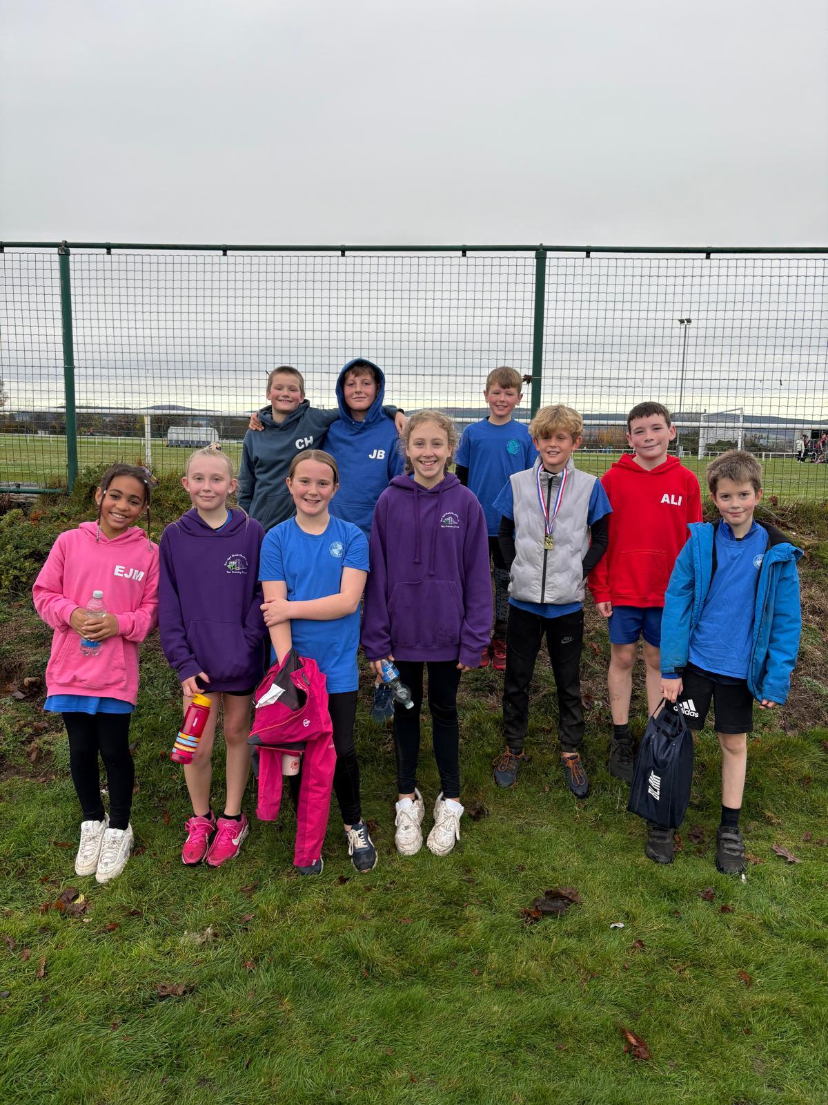 10 school pupils lined up pupils on a sports pitch