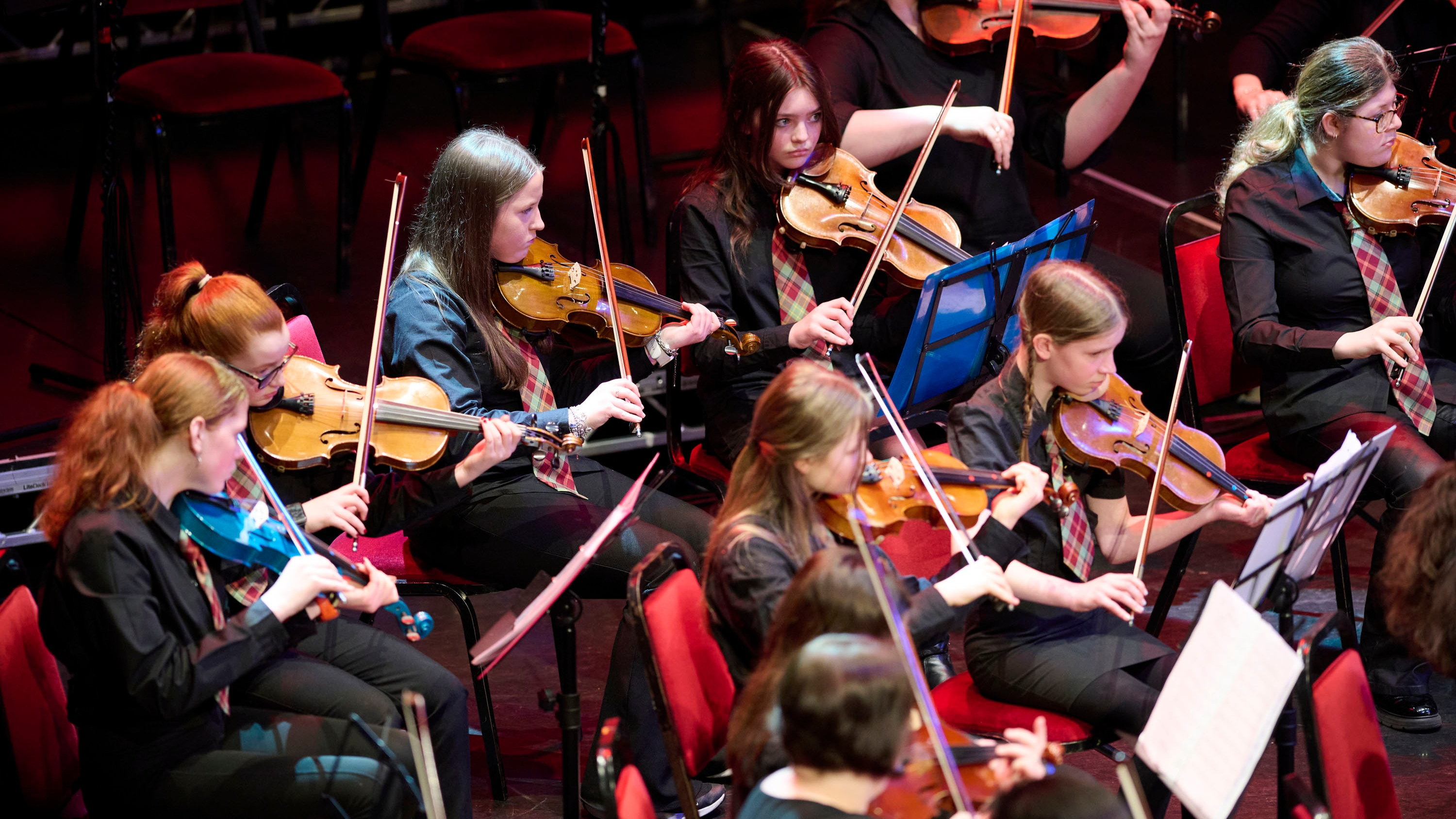 Group of young violinists performing on stage