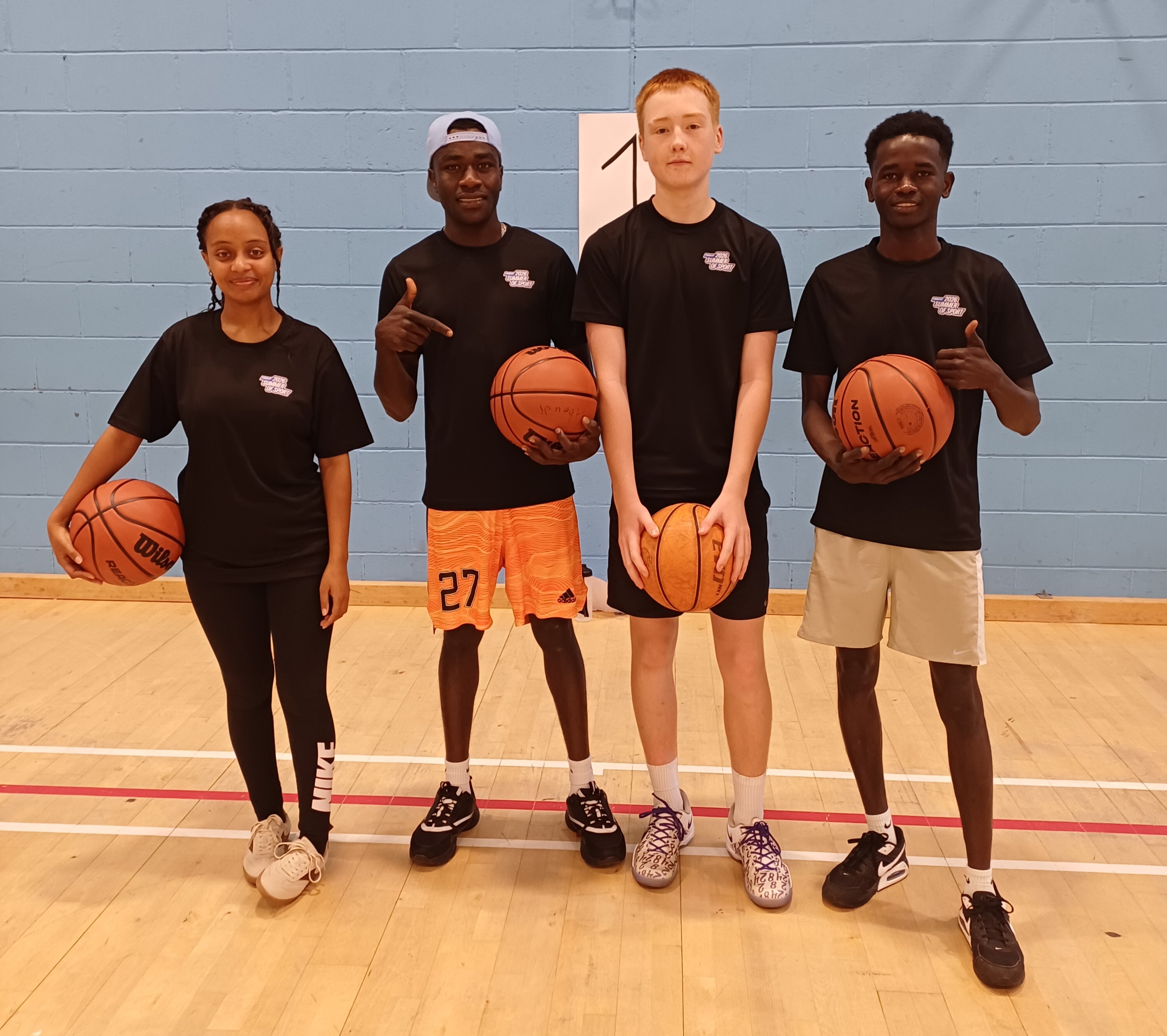 Four young basketball participants posing together