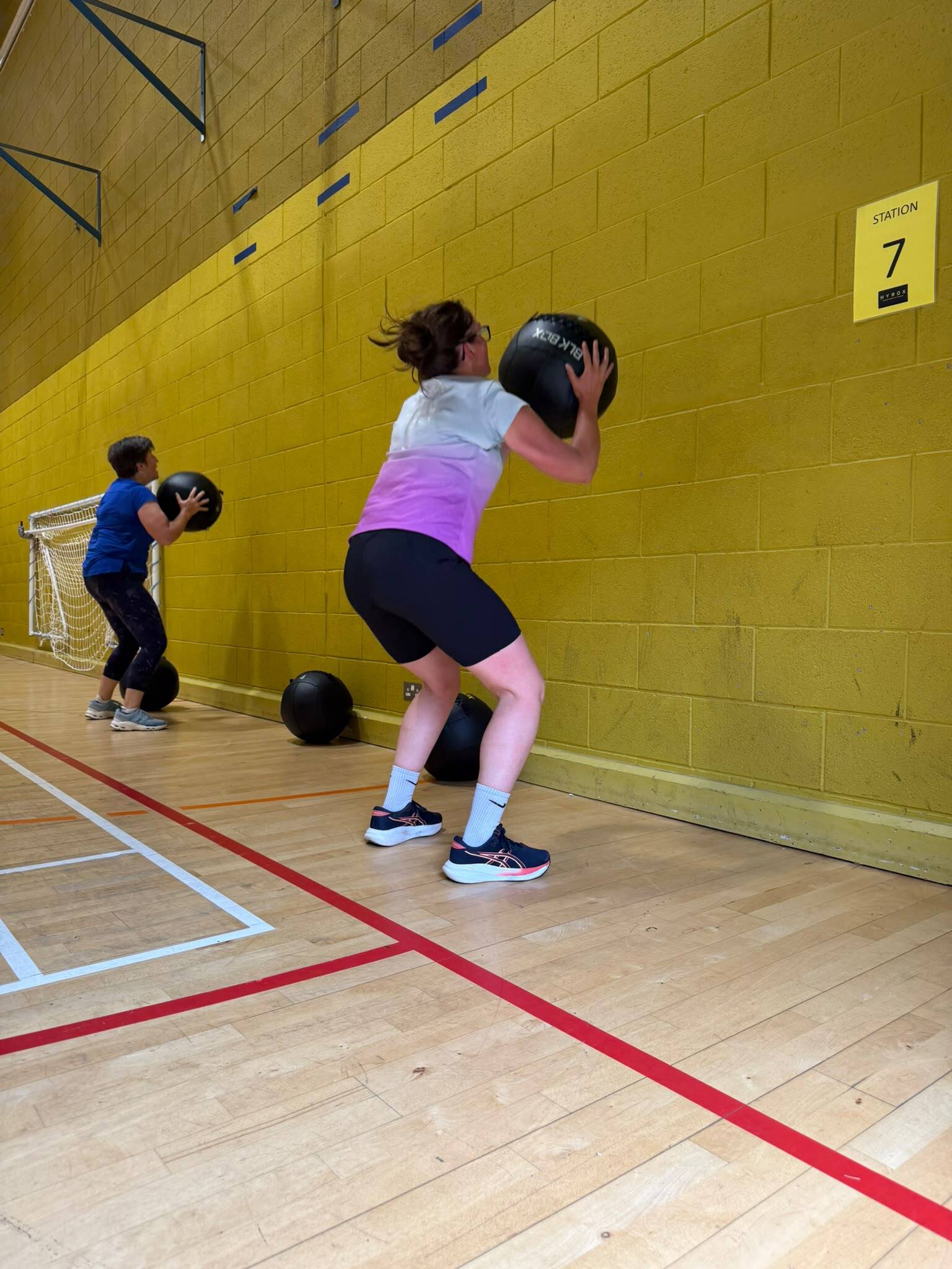 Woman lifting wall ball at station seven