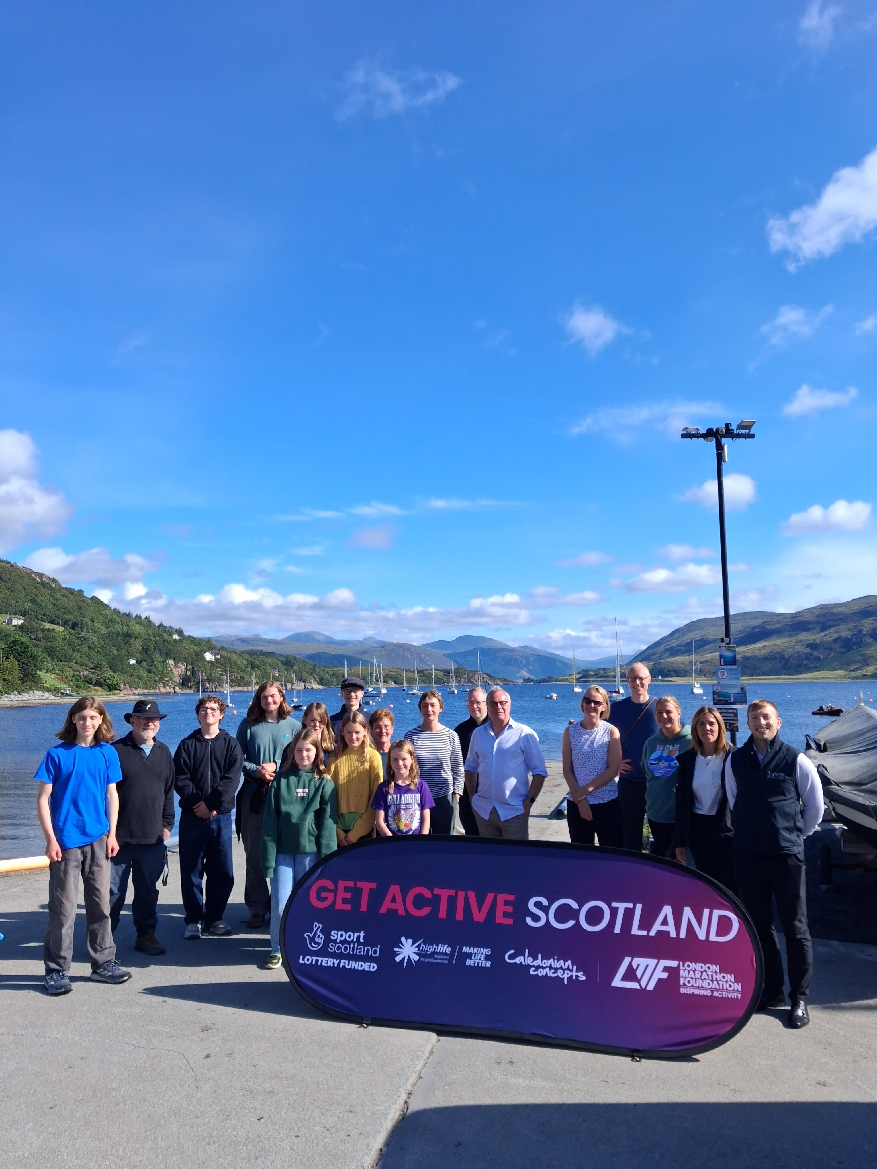 Group with Get Active Scotland banner beside loch