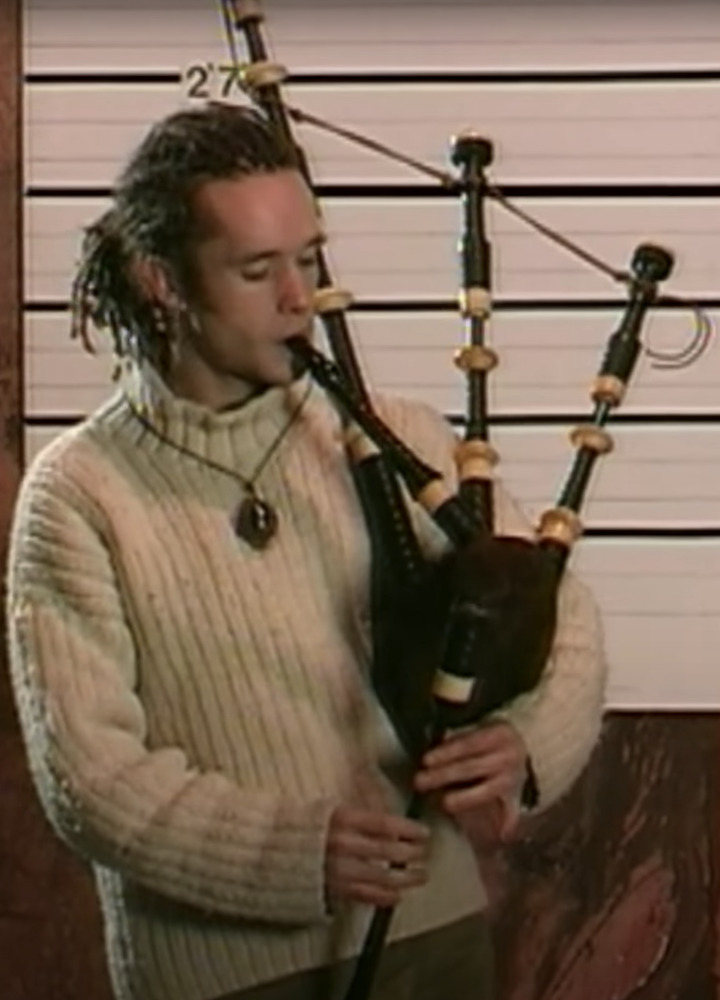 Martyn Bennett playing Highland bagpipes, wearing a white sweater