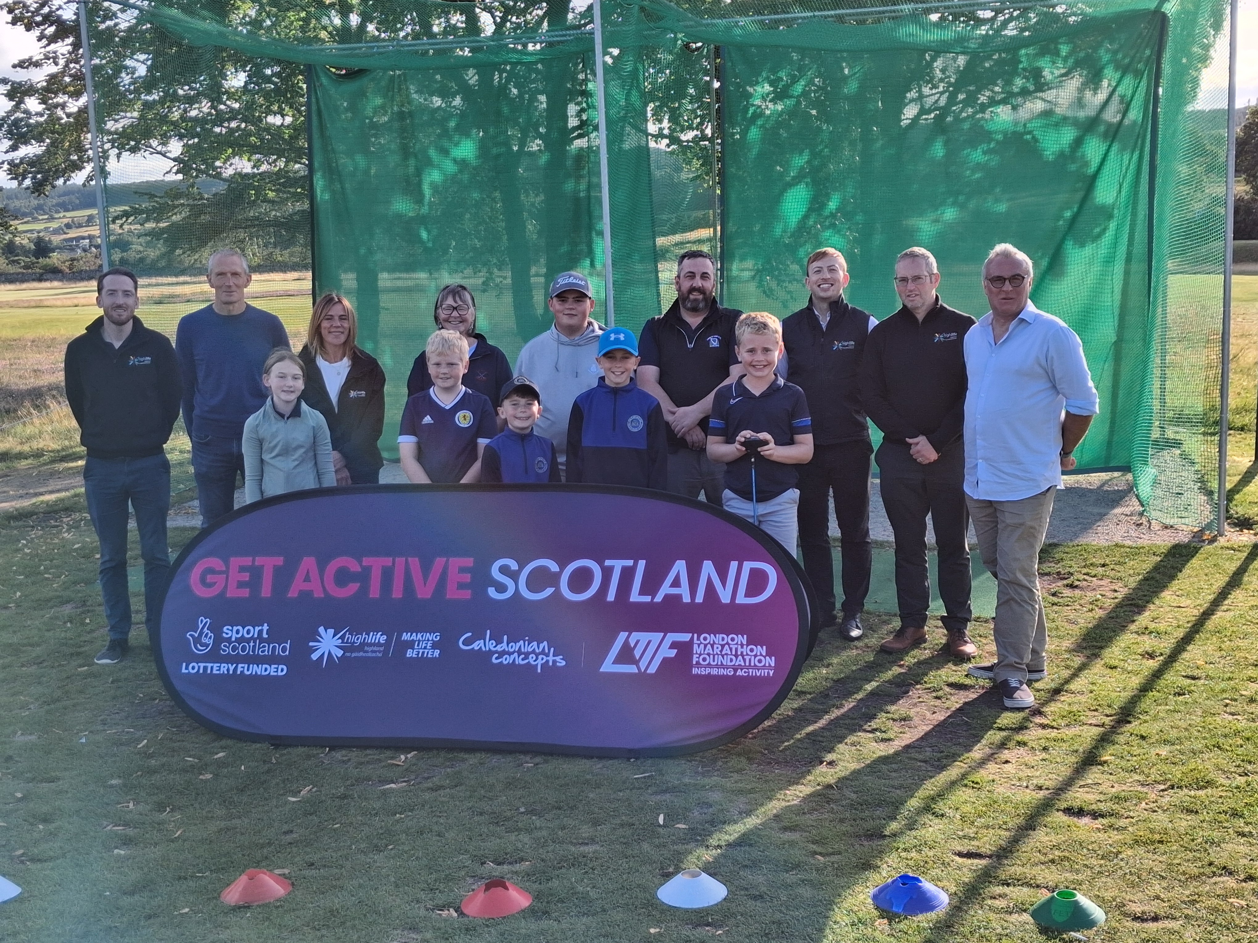 Group with Get Active Scotland banner at golf range