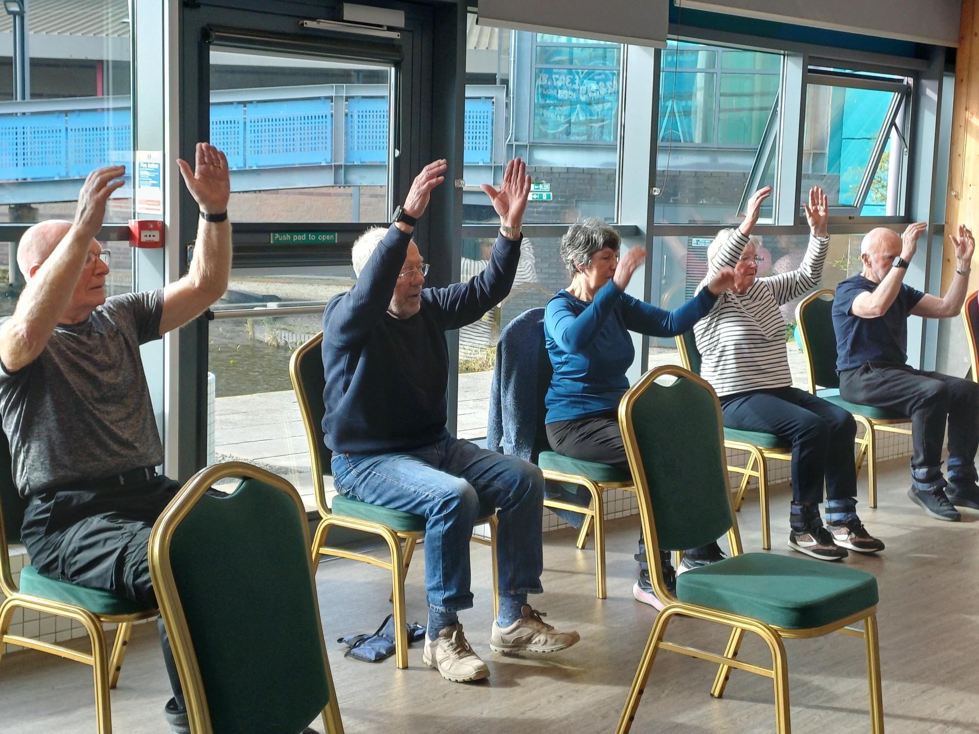 Parkinson's class doing seated arm exercises