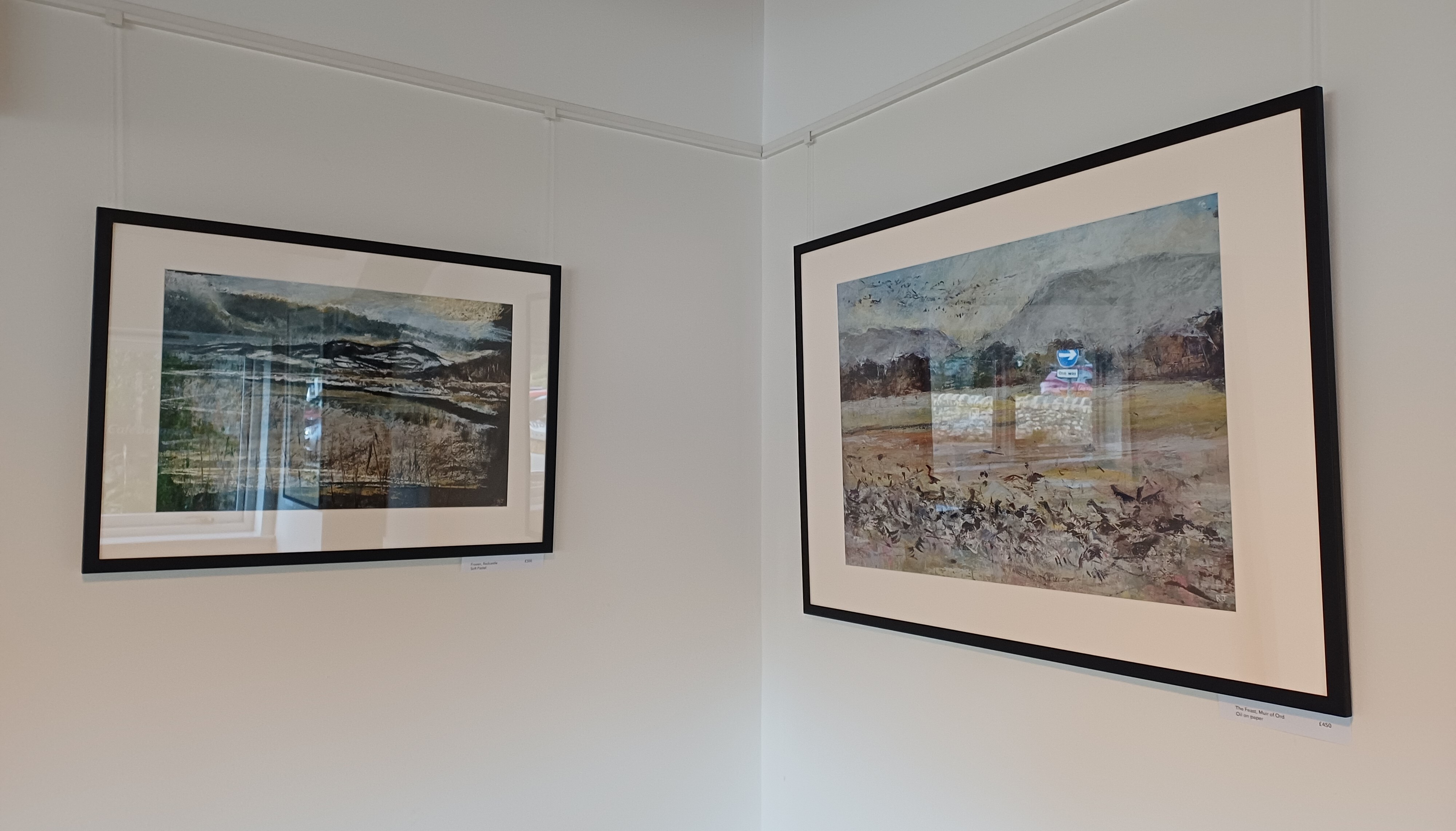 Framed coastal paintings on gallery wall