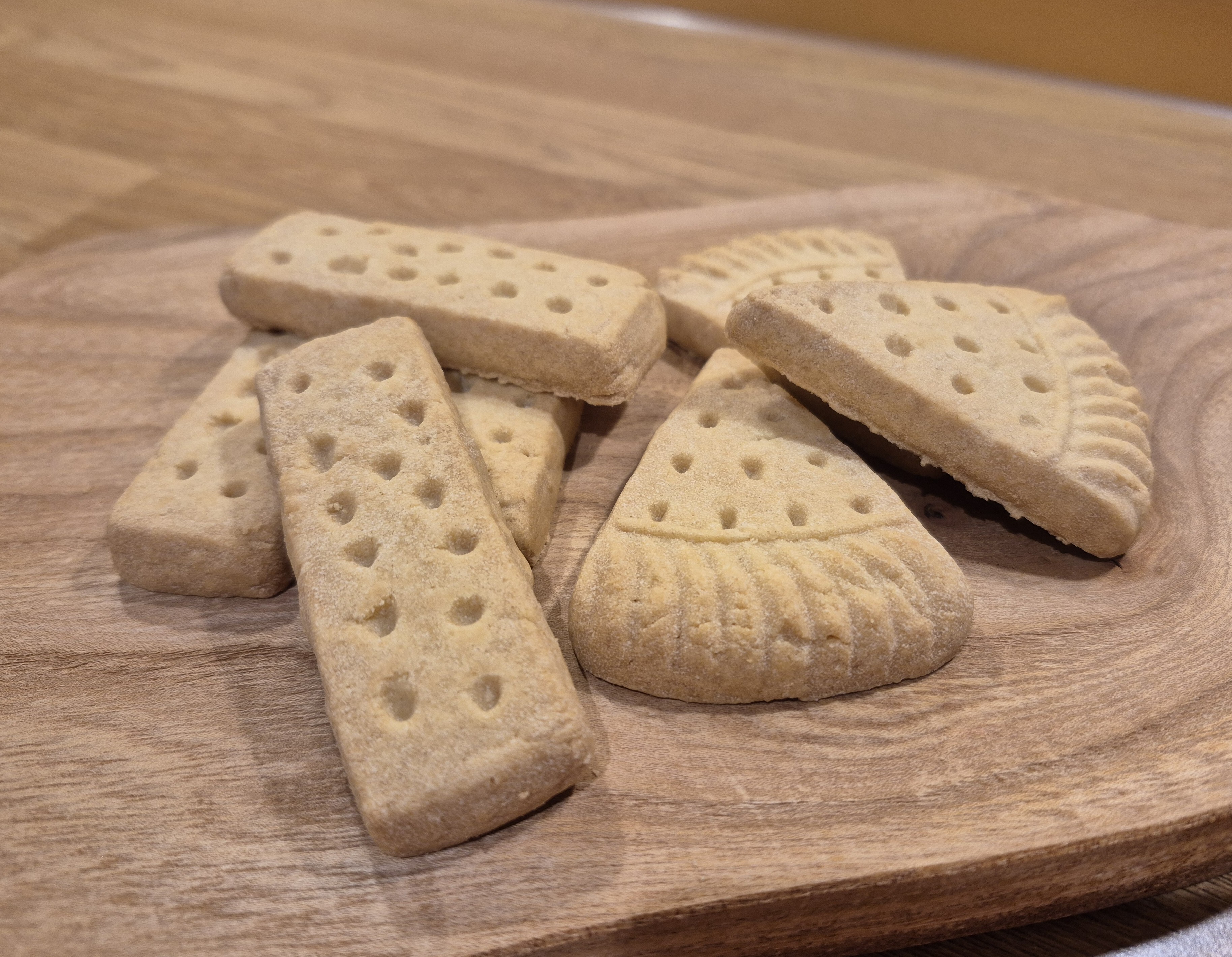 A selection of traditional shortbread fingers and petticoat tail pieces arranged on a wooden board