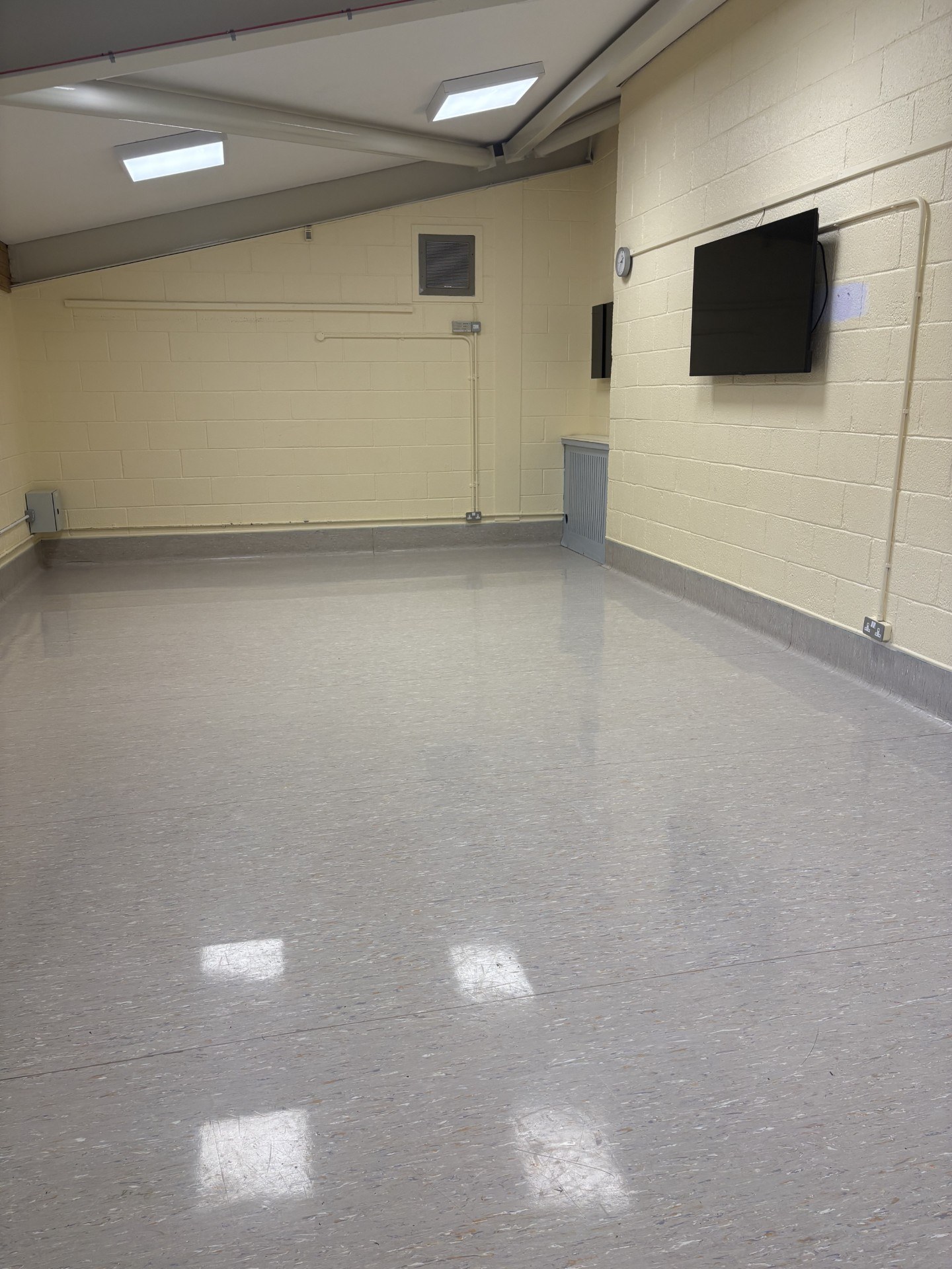 The Gordon Suite features laminate flooring and stone walls, complemented by a wall-mounted television screen.