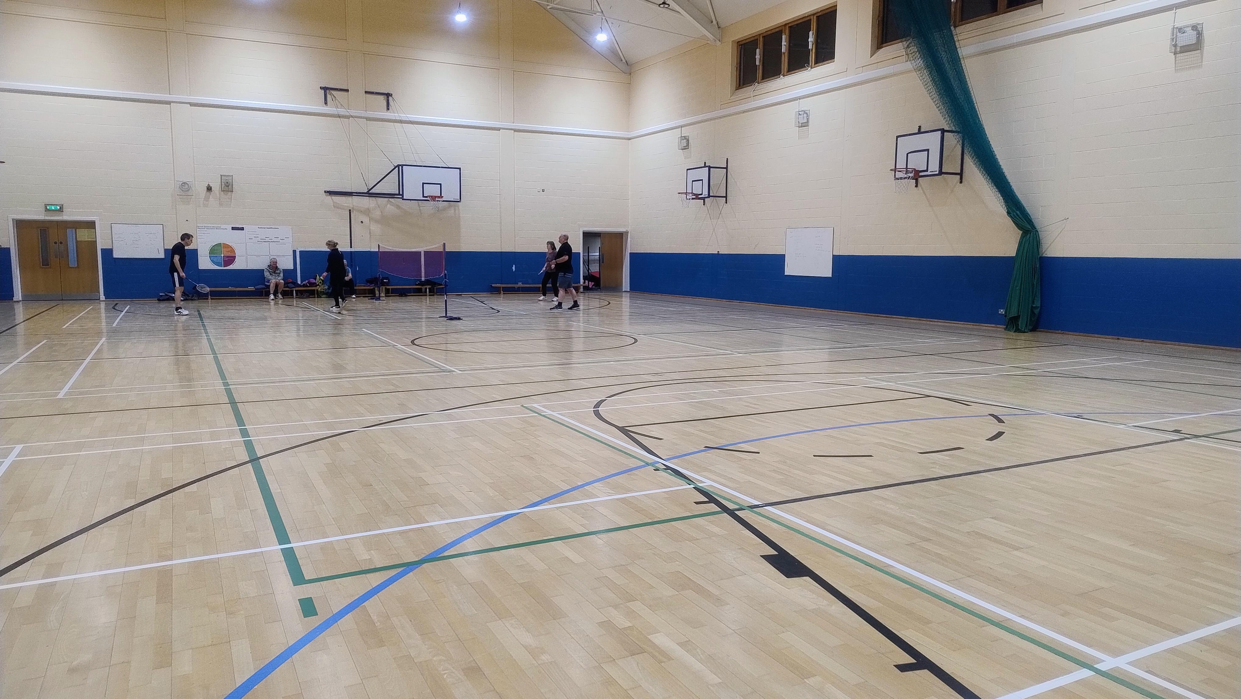 A Games Hall featuring court markings for both basketball and badminton on the floor, along with multiple basketball hoops mounted on the walls.