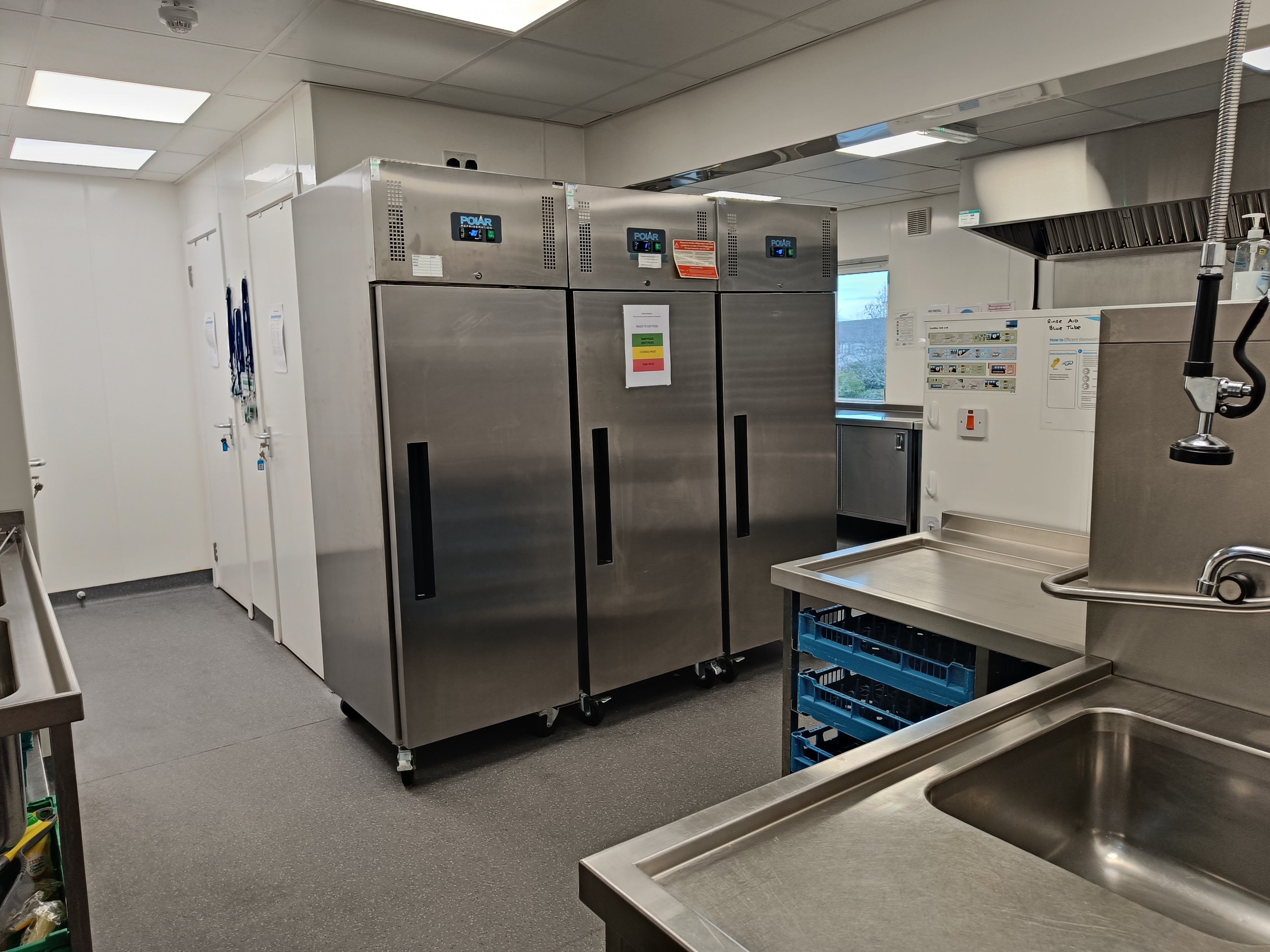 Catering kitchen with sink and fridge freezers.