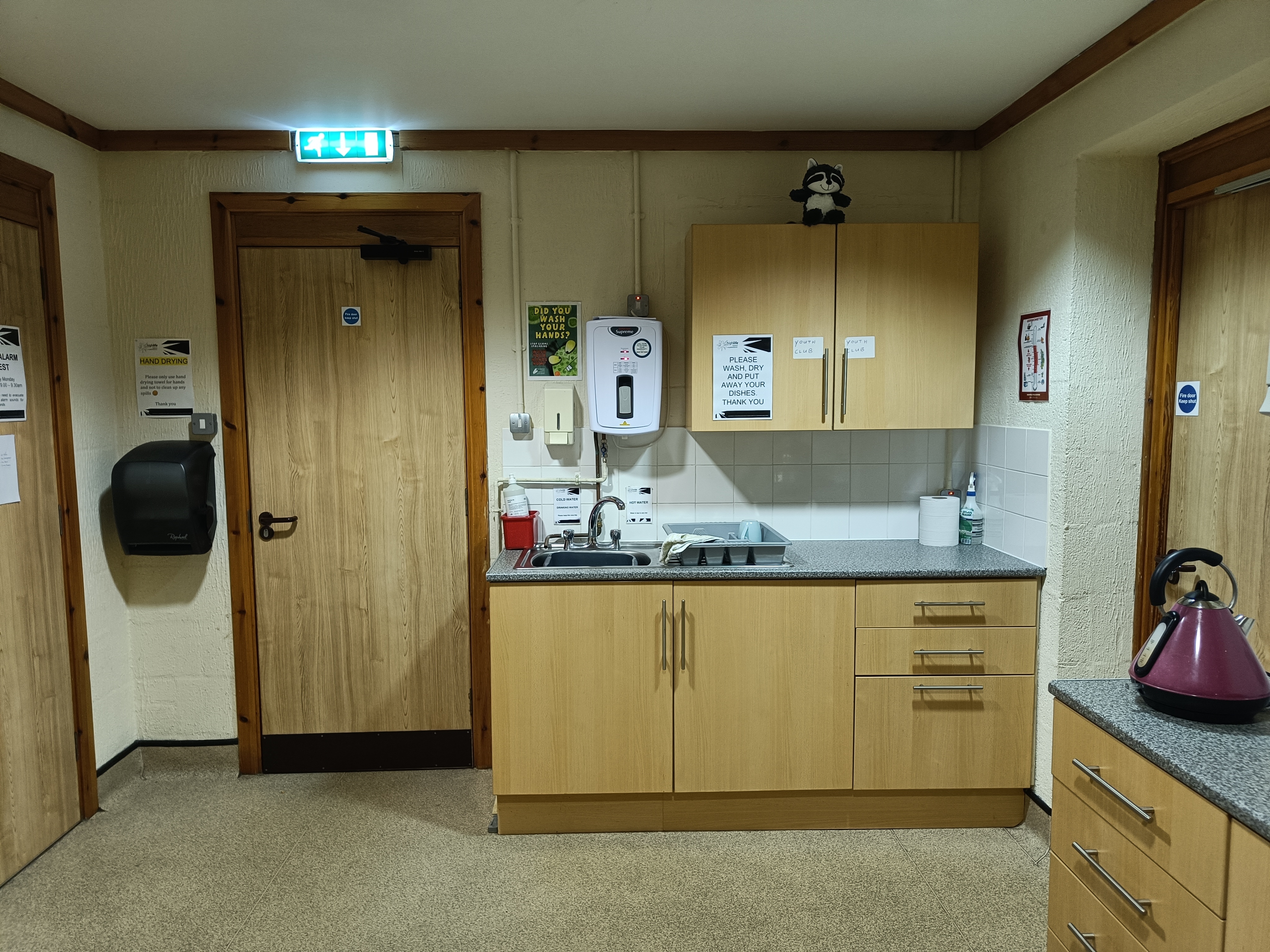 A kitchen equipped with cabinets, work surfaces and a sink.