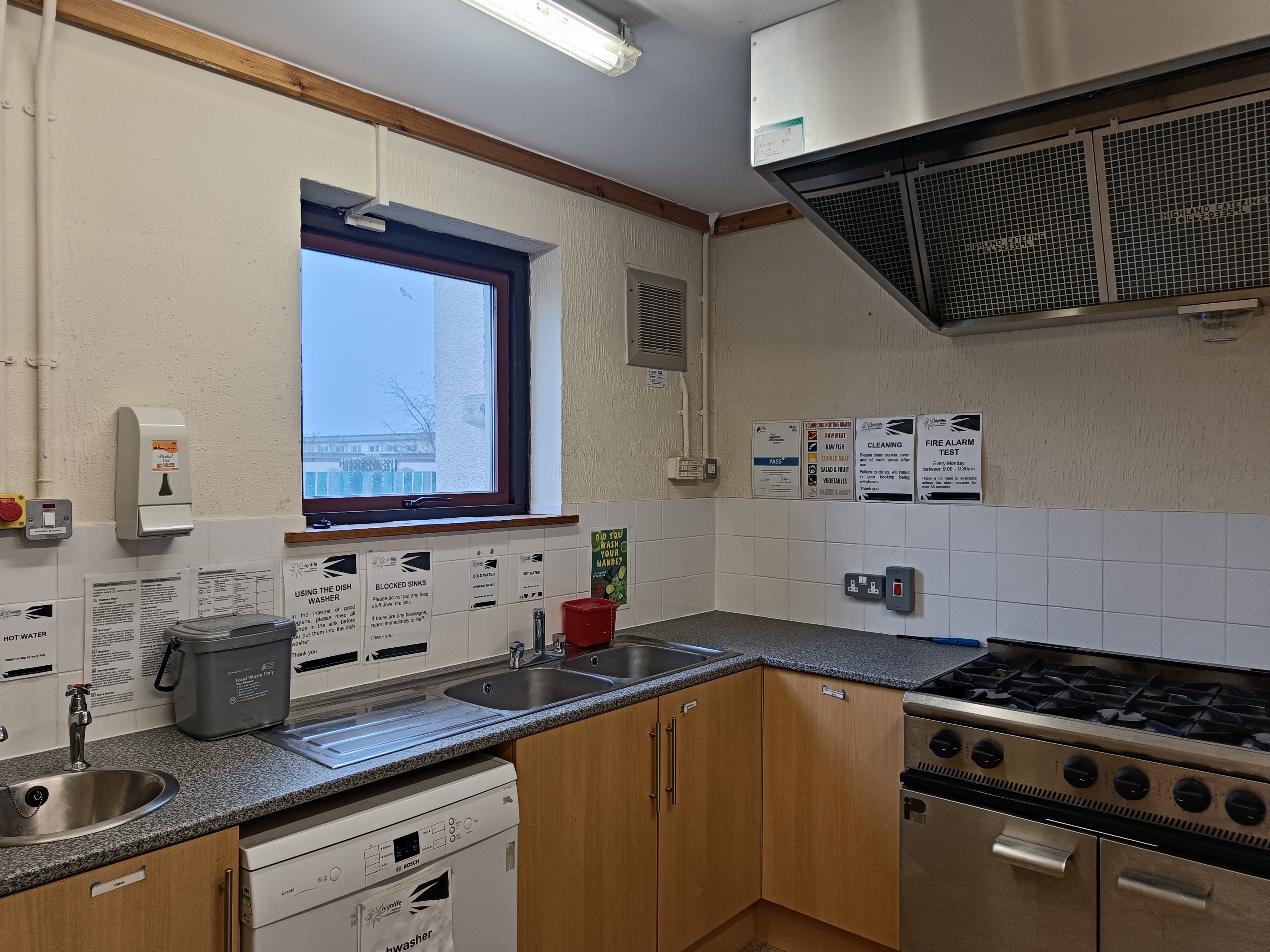 A kitchen equipped with cabinets, work surfaces, sink, an oven & hob and a dishwasher.