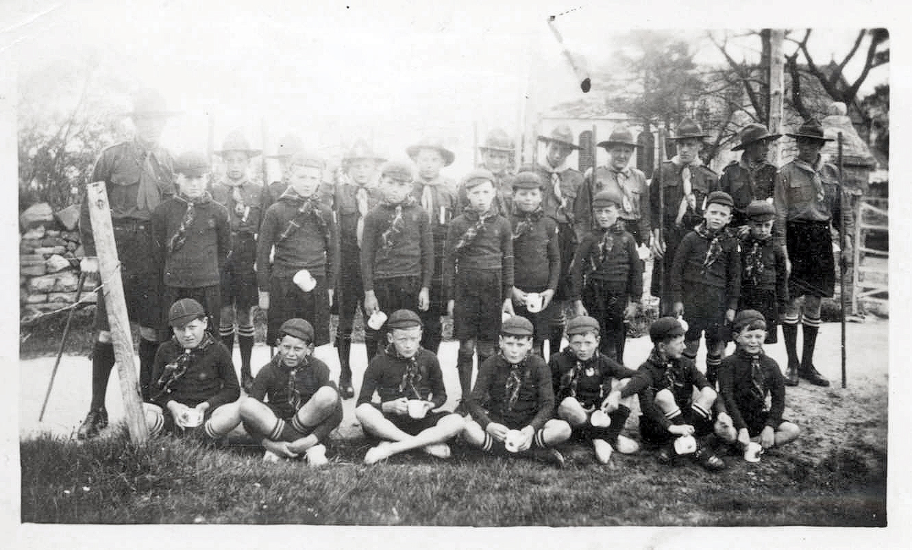 Black and white photograph of the Ullapool First Troop Scouts and Cubs, taken during Silver Jubilee celebrations for King George V, with boys in uniform holding mugs.