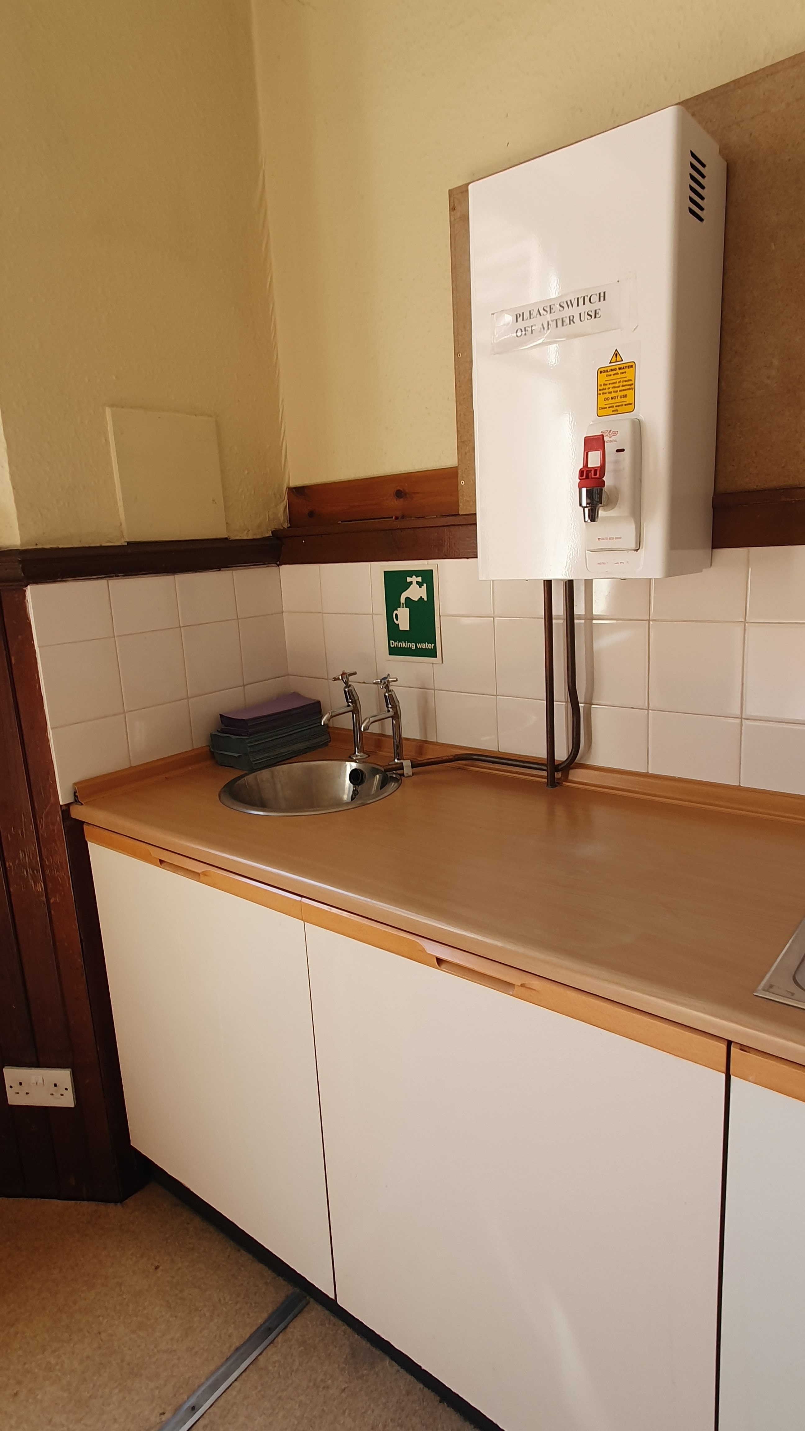 A kitchen equipped with cabinets, work surfaces and a sink.
