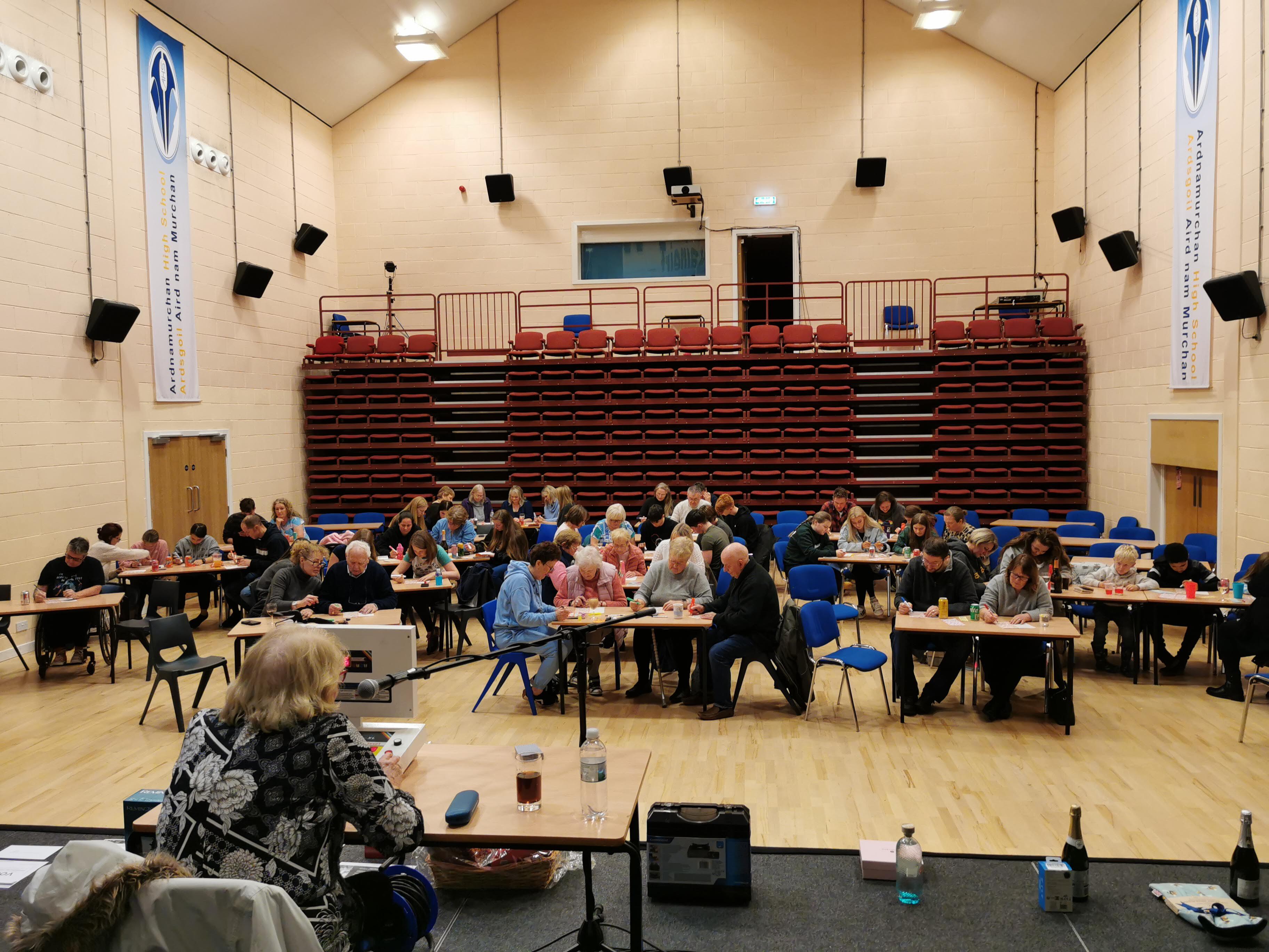 The room is being utilised for a bingo event, featuring tables filled with participants and a designated bingo caller.