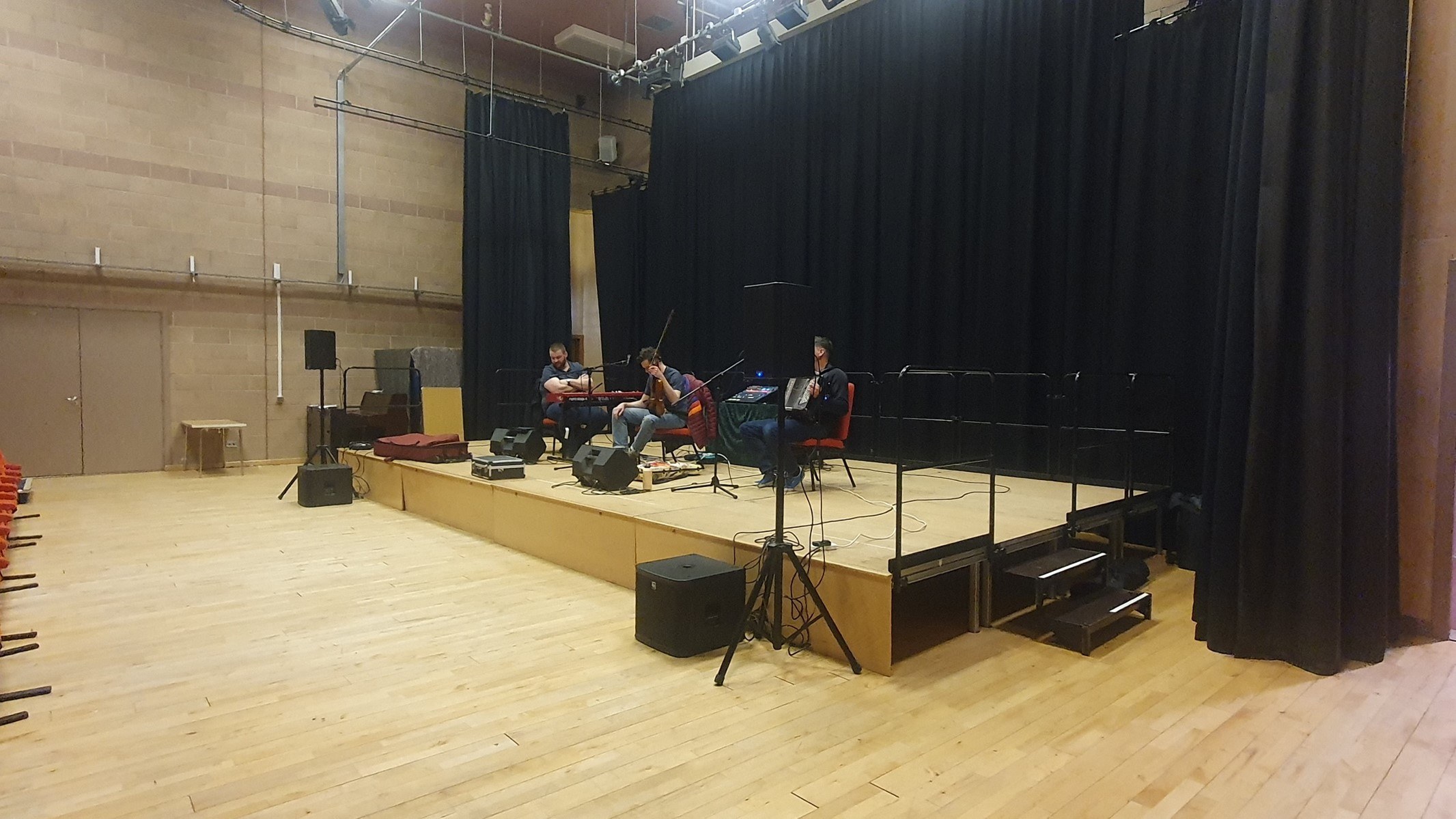 A modular stage can be installed in the theatre and constructed in various sizes according to the performance requirements. Back and side drapes encircle the stage, complemented by an overhead lighting rig to enhance the overall production.