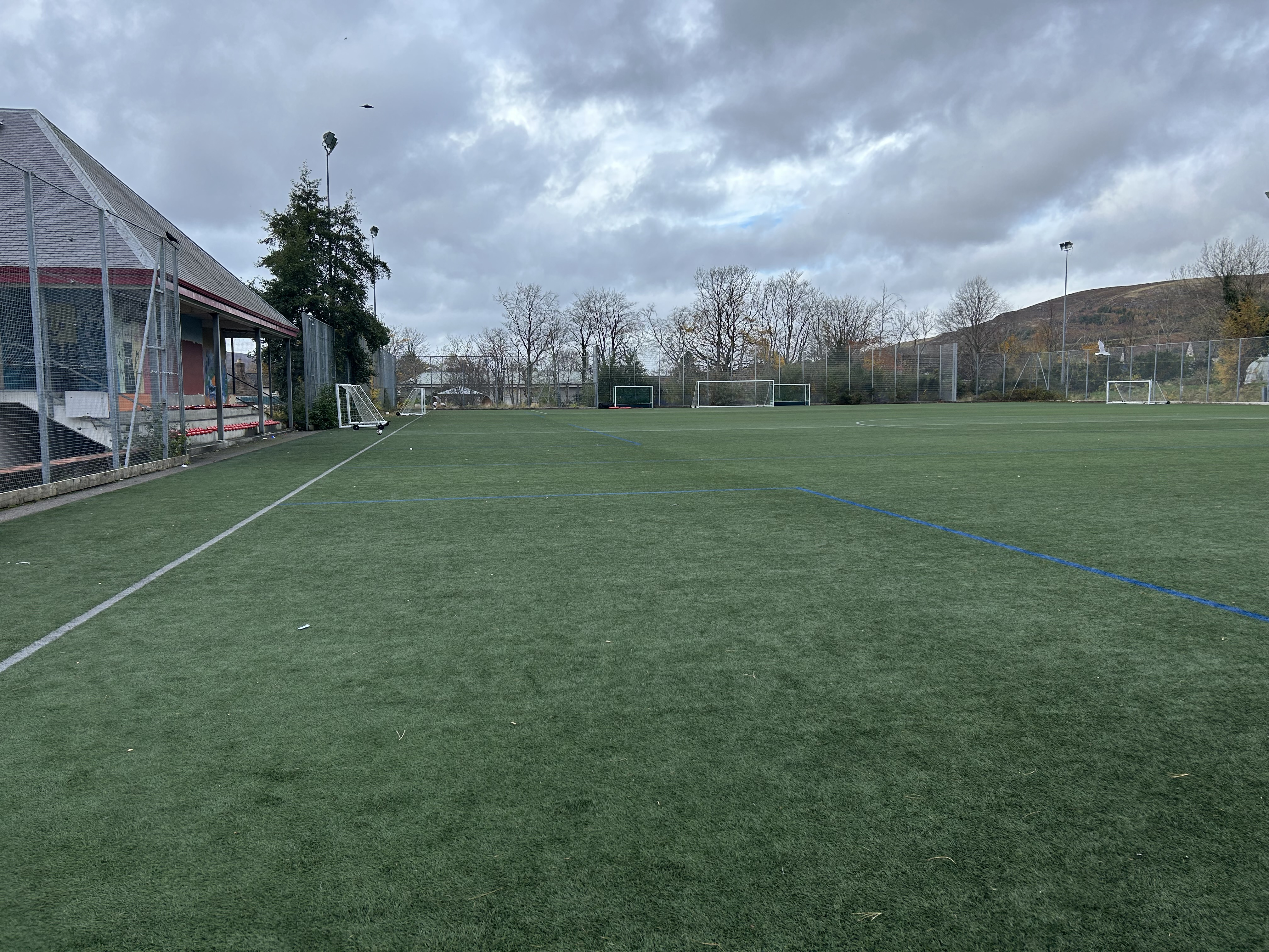 The Astroturf pitch is an expansive area equipped with goals and spectator seating.