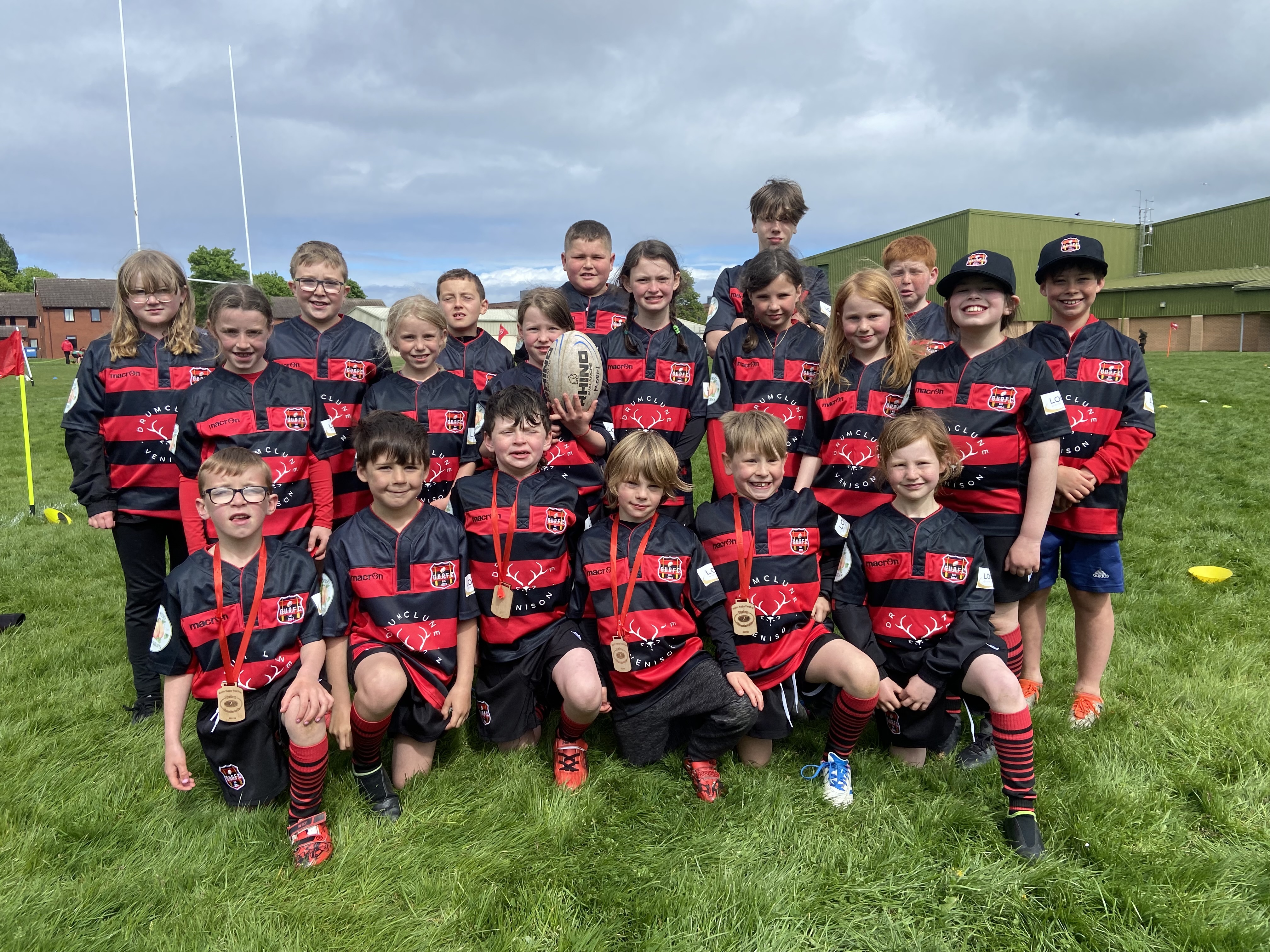 Glen Urquhart Rugby FC kids in their red and black strips in a rugby pitch.