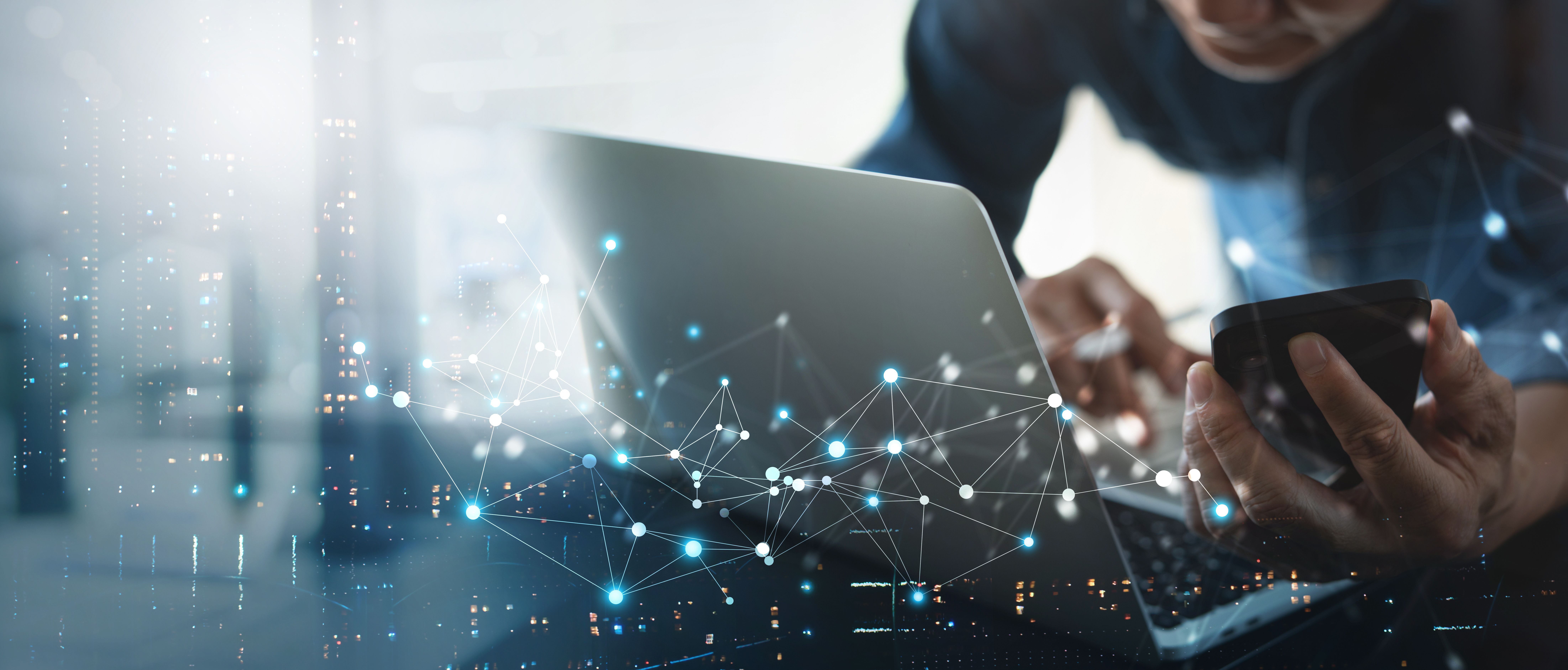 Person using a laptop and mobile phone