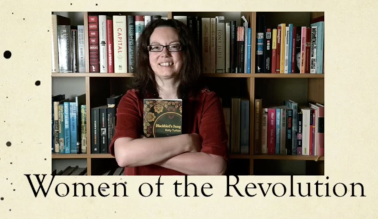 A person stands in front of a large bookshelf filled with books, holding a copy of Madame’s Song close to their chest with arms crossed. Below the image, the text reads “Women of the Revolution.”