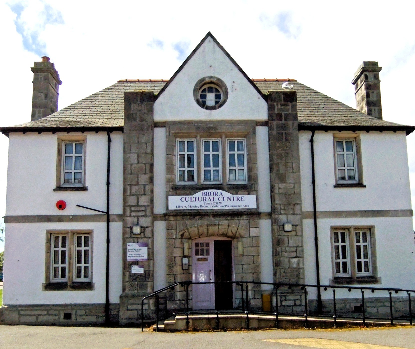 Front of Brora Cultural Centre, a white two-storey building with stone trim, central entrance, and sign above door.