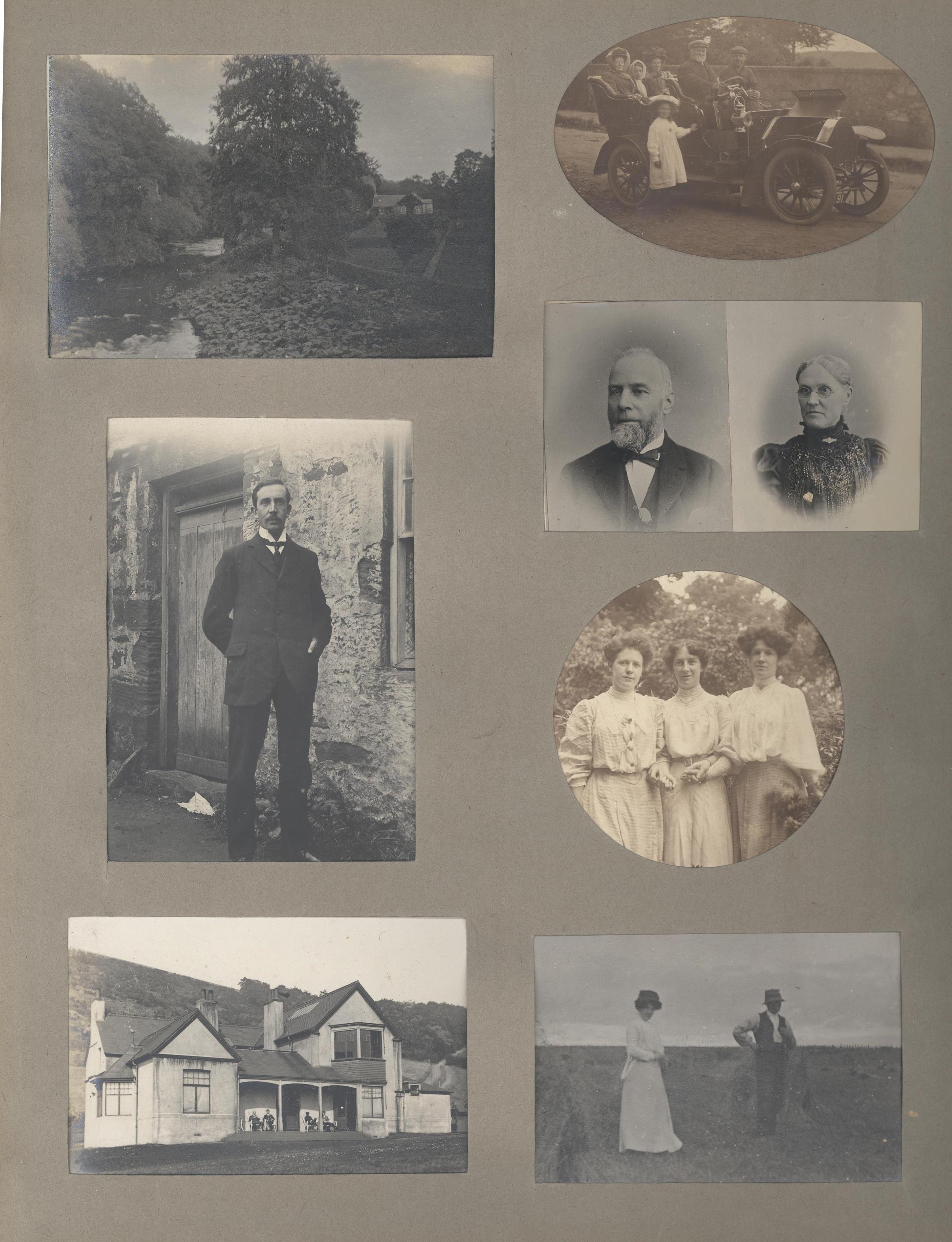 A scrapbook page featuring six black-and-white photographs arranged on a grey background. The images include: a scenic view of a river with trees and a stone wall; an early motor car with several people seated inside and a child standing beside it; a full-length portrait of a person in formal attire standing in front of a stone building; two small head-and-shoulder portraits placed side by side; a circular photo of three people outdoors wearing light-colored dresses; and a rectangular photo of two people standing on open ground near the coast, with one wearing a hat. At the bottom left is a photo of a large house with a veranda set against a hillside.