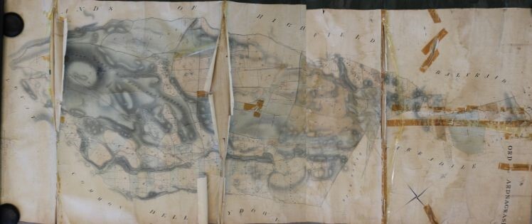Damaged historical map showing heavy creases, tears, and multiple strips of old tape repairs. The map is discolored with staining and faded ink, and sections are misaligned due to severe splits along fold lines.