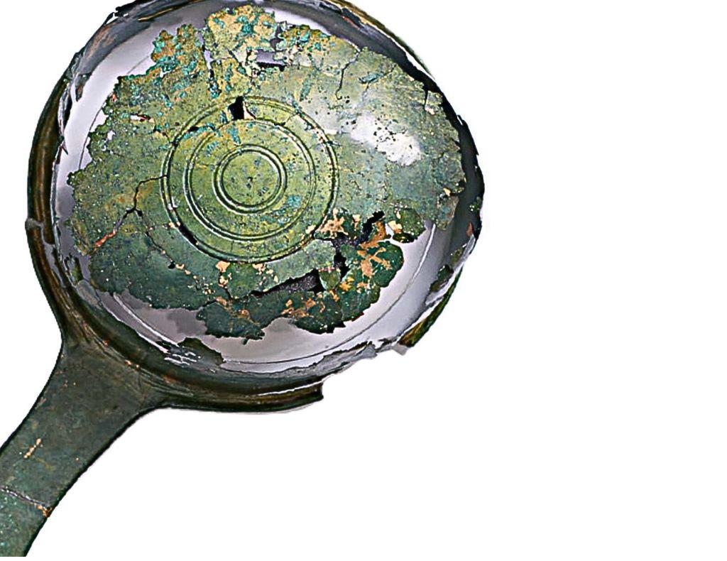 Reconstructed Roman wine dipper with green patina and restored structure, prepared for museum display.