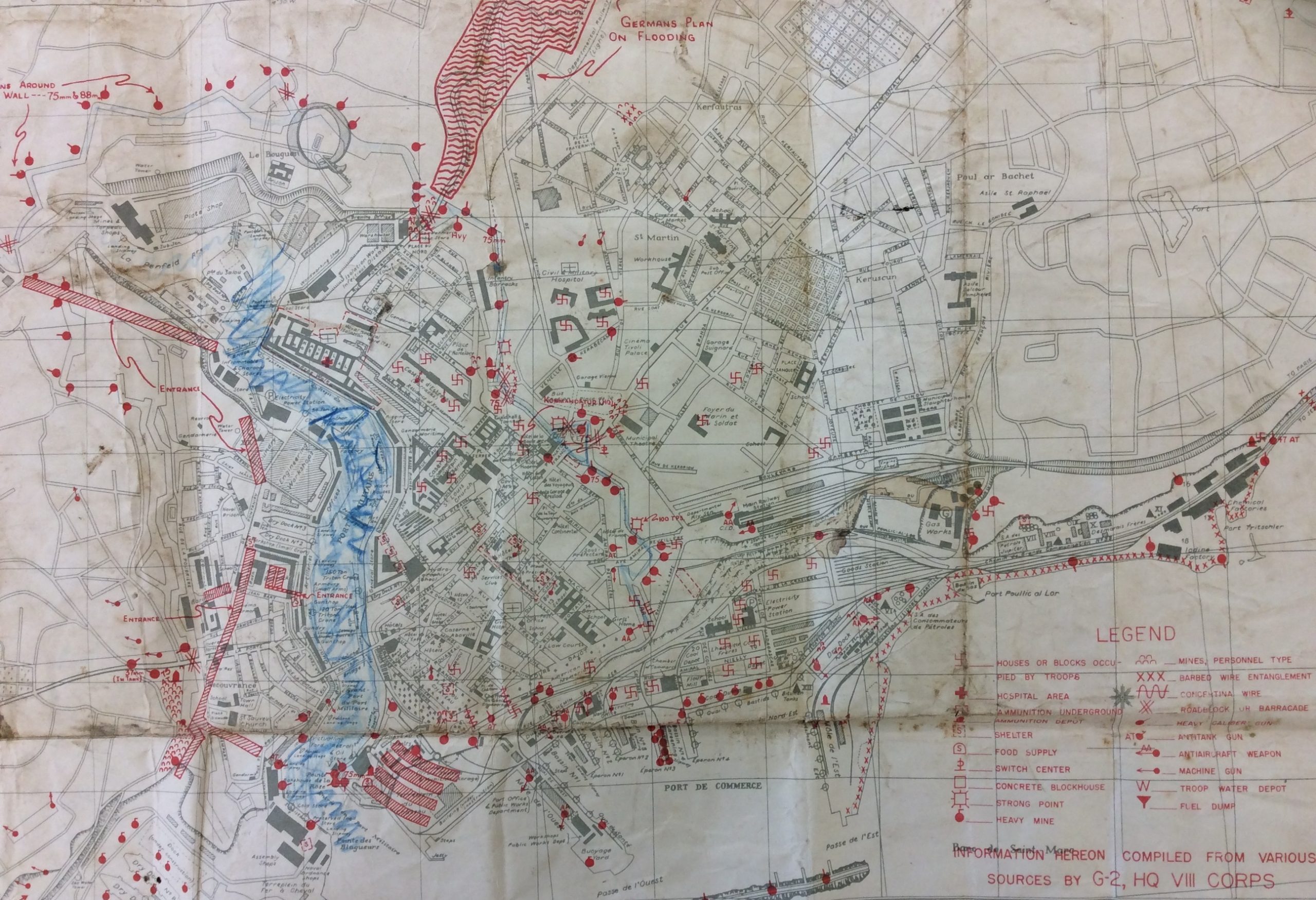 A map of the town of Brest coloured and annotated in blue and red ink.  A key indicates that markings include houses occupied by troops, ammunition depots, food supplies, barbed wire entanglements and machine guns