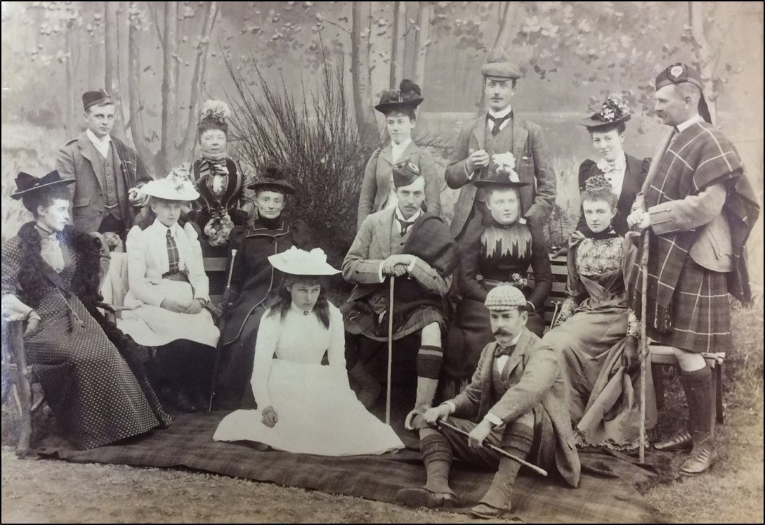 A formal photograph of a group of men and women in Highland dress
