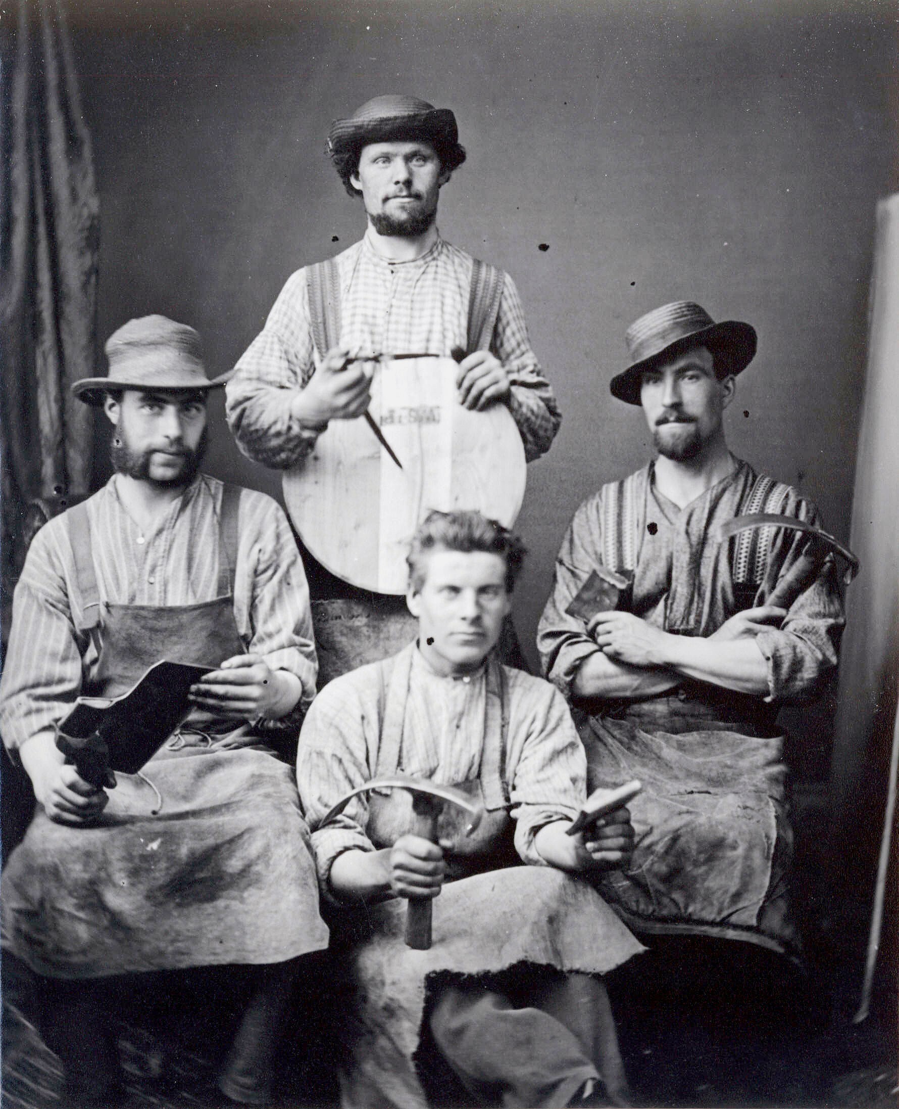 Four coopers pose with tools of their trade c.1890, three of them are wearing hats.
