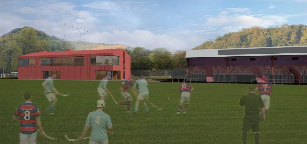 An artists impression showing the new red coloured pavilion building next to the Bught Park grandstand. In the foreground is the sports pitch with a group of people playing shinty super imposed into the image.