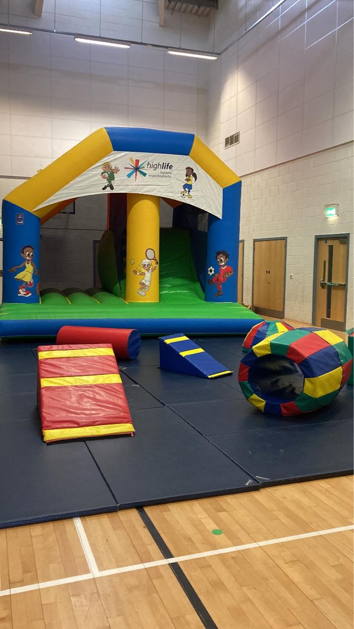 A vibrant bouncy castle set up with soft play items.
