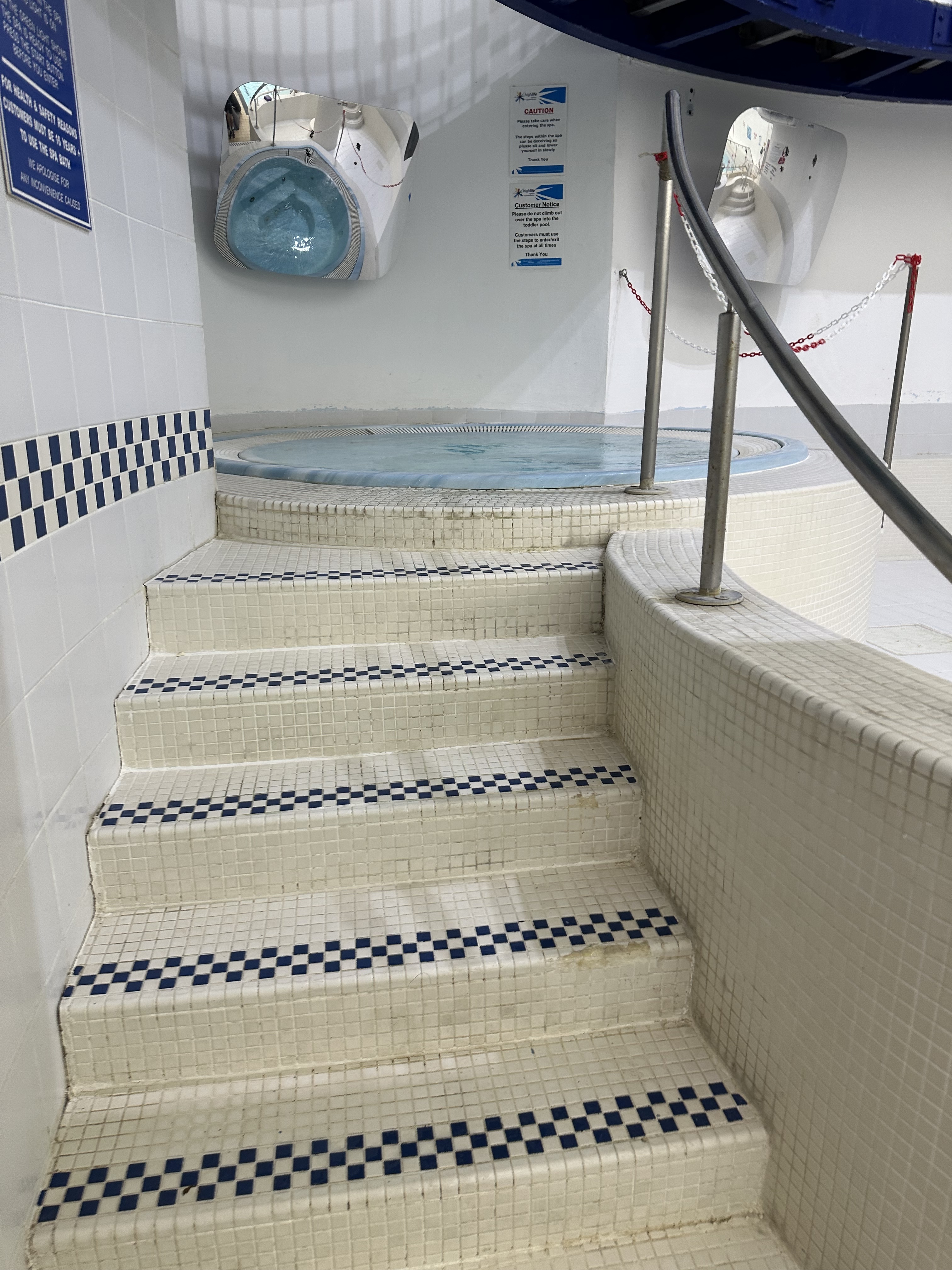 Tiled steps leadng to jacuzzi bath.
