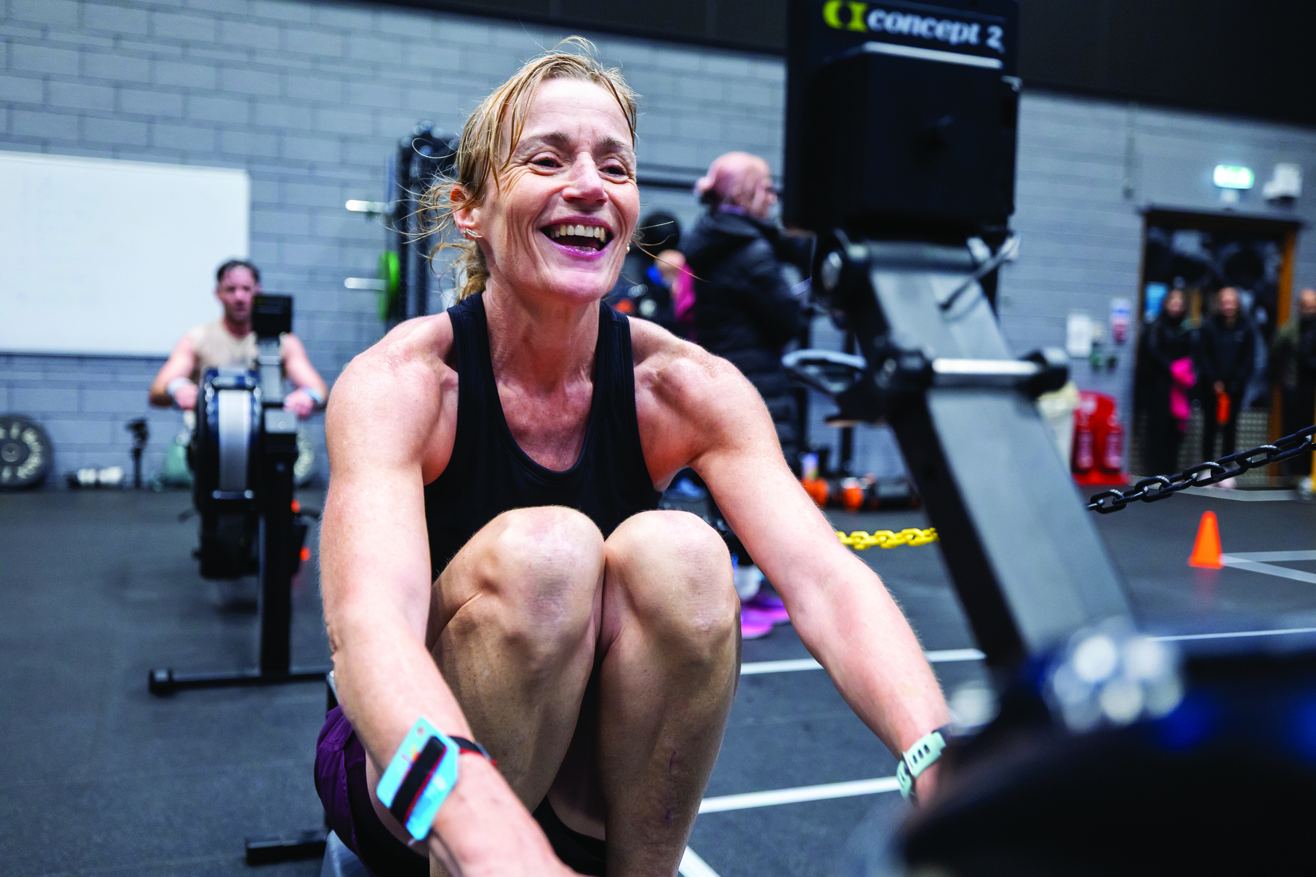 Woman laughing during a HYROX training session